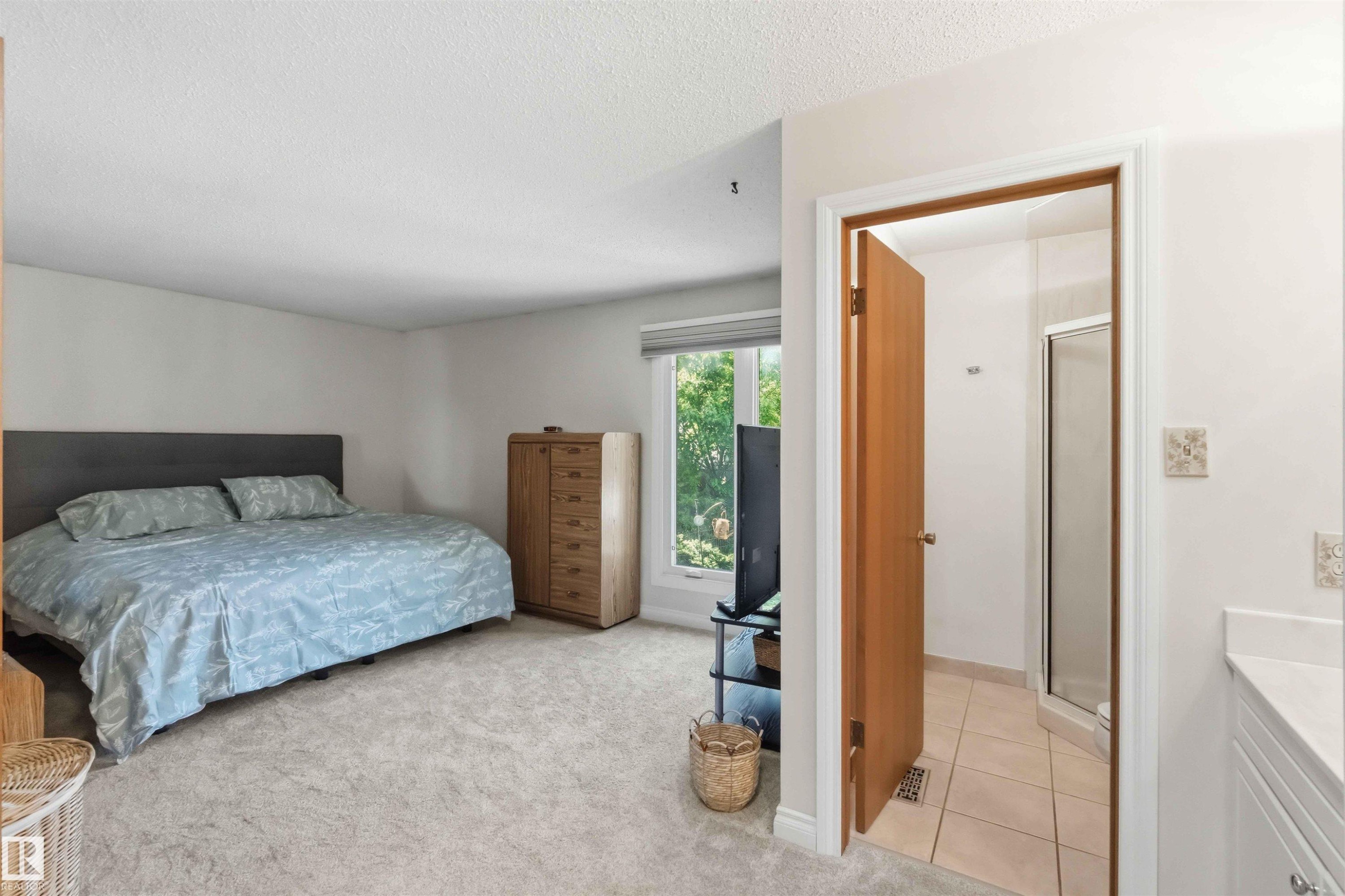 Spacious carpeted room with light-colored walls and a large window - 31 Gariepy Crescent, Edmonton, AB