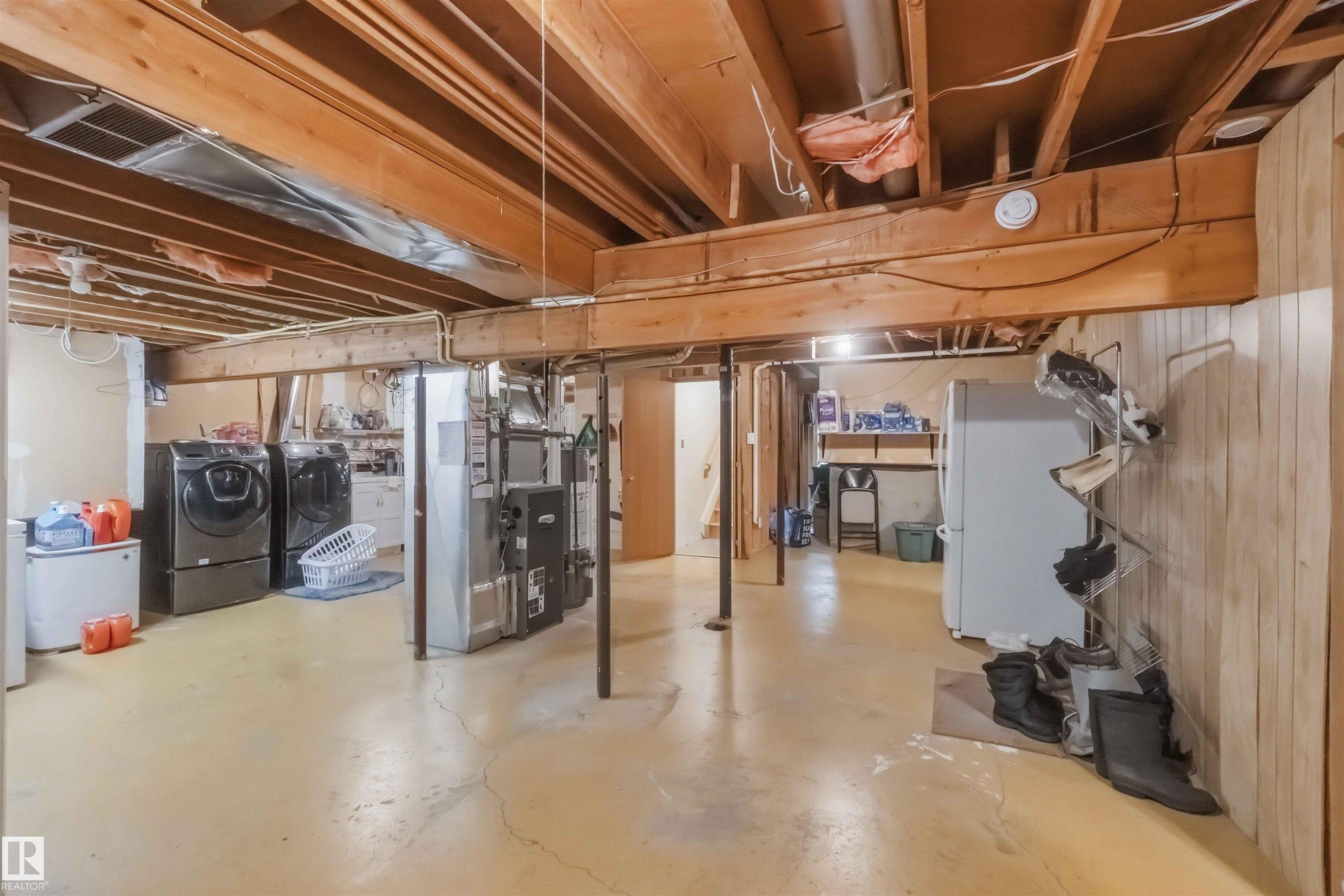 Unfinished basement featuring exposed wood joists and concrete flooring - 31 Gariepy Crescent, Edmonton, AB