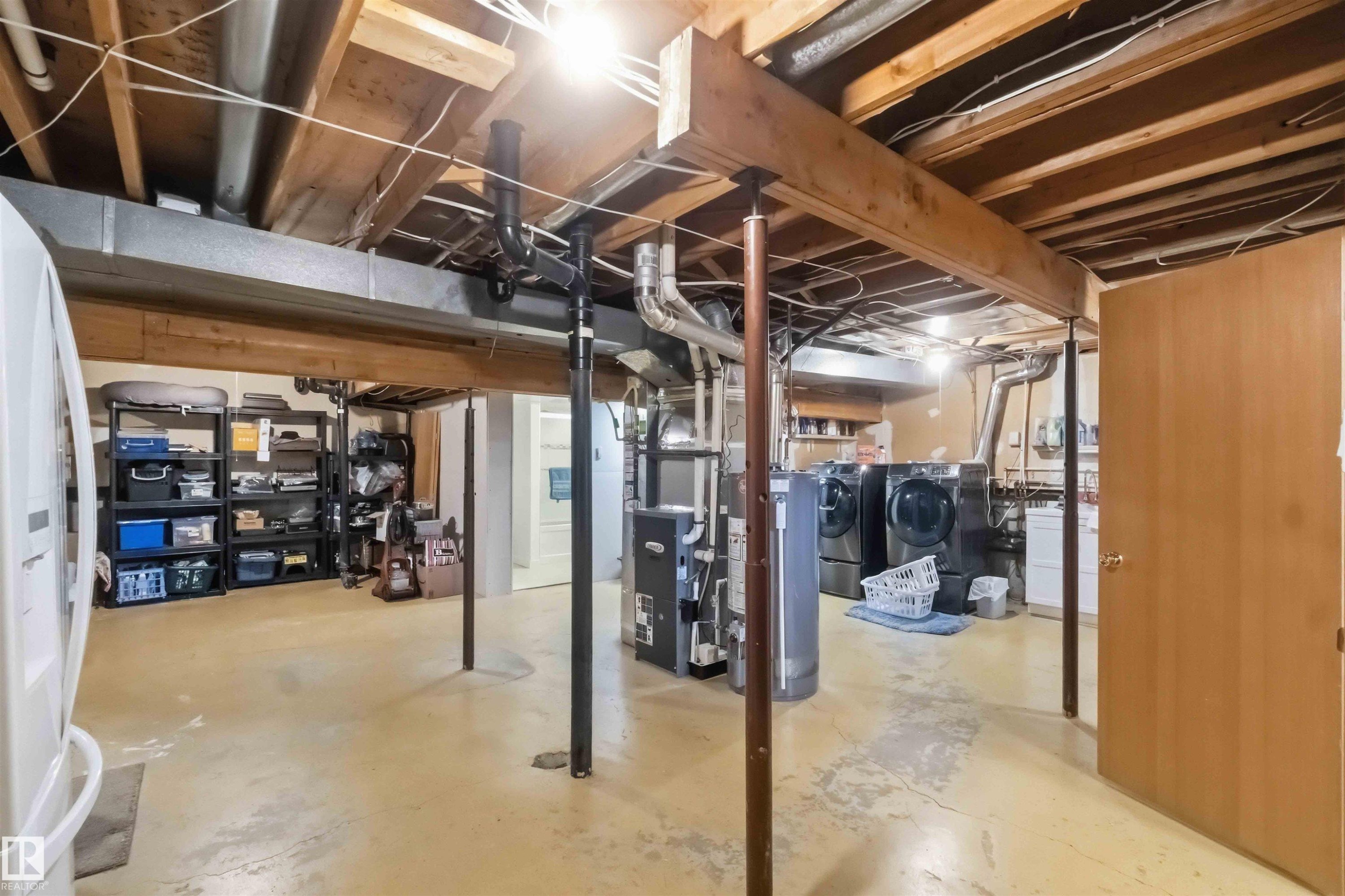 Expansive lower level featuring exposed overhead joists, wood beams, and a utility area with a water heater - 31 Gariepy Crescent, Edmonton, AB