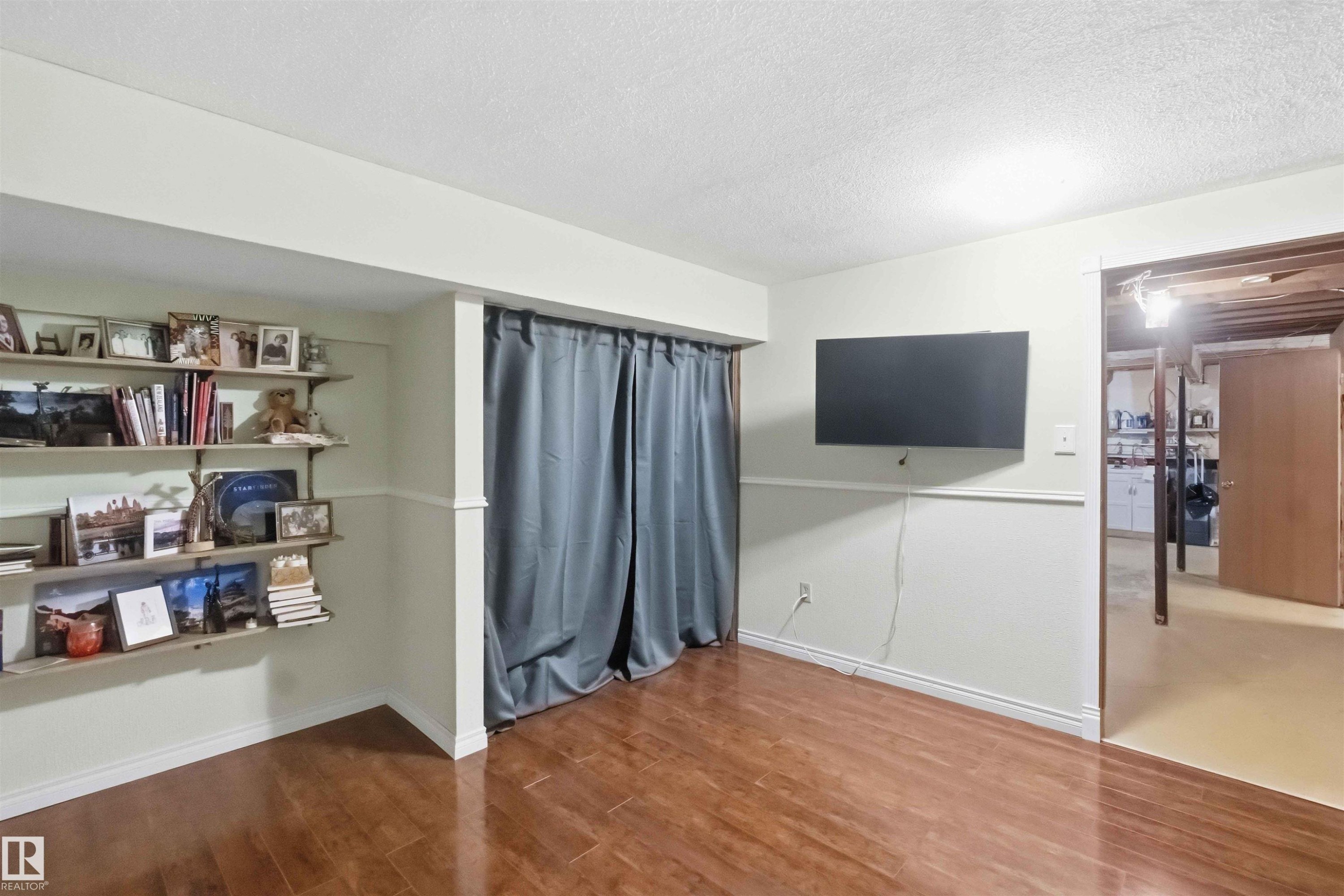 Finished lower level featuring wood-finish flooring, wainscoting, and built-in shelving - 31 Gariepy Crescent, Edmonton, AB