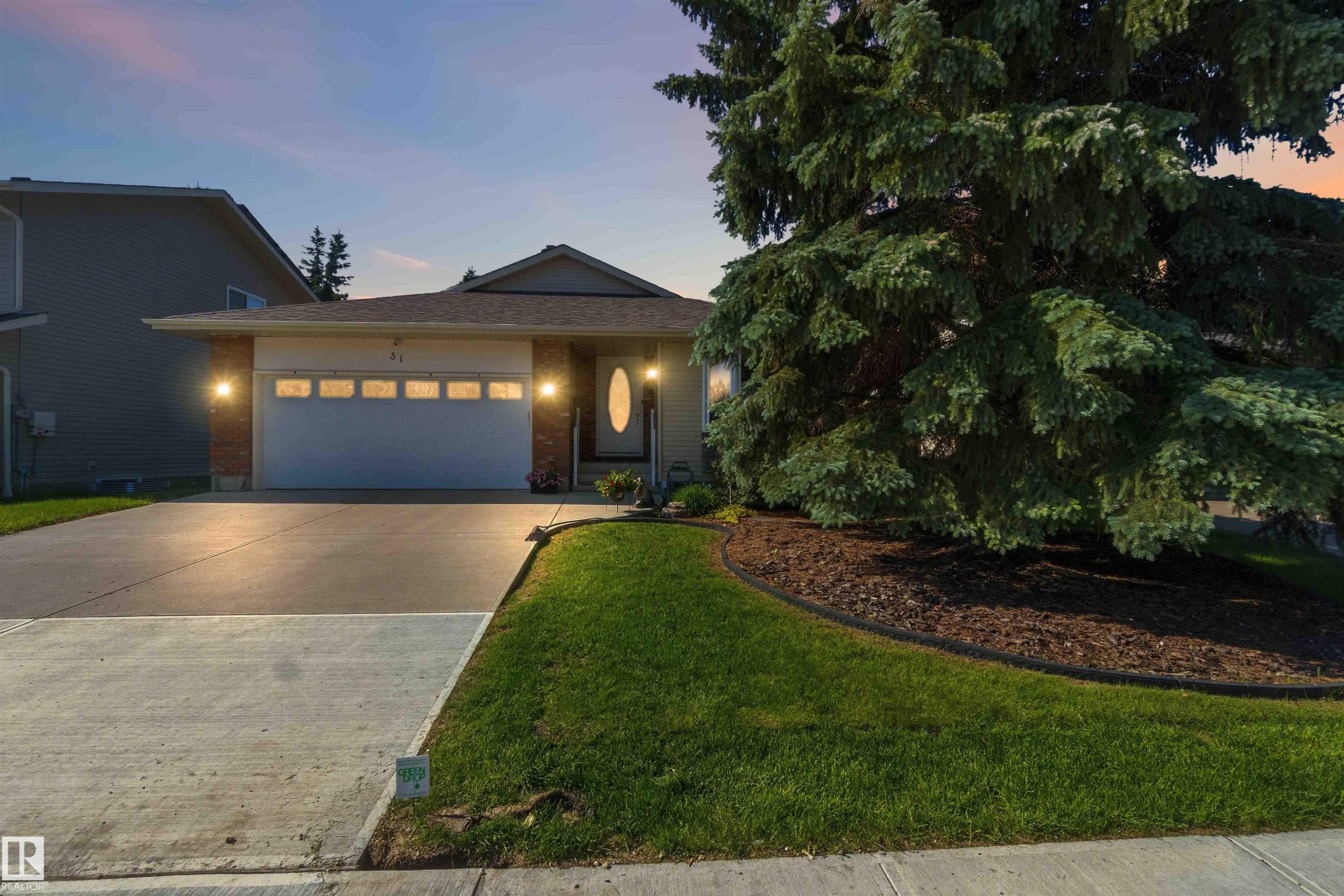 Single-story residence featuring a front entry garage, concrete driveway, and brick accent siding - 31 Gariepy Crescent, Edmonton, AB