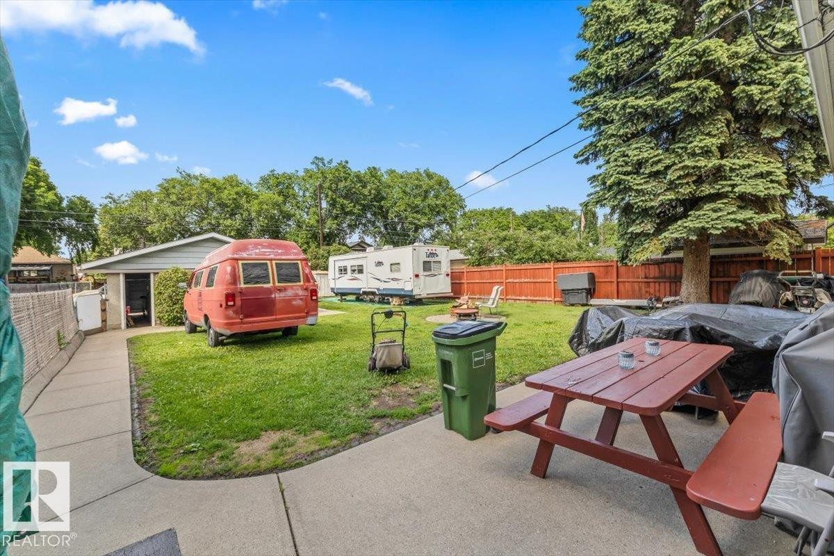 Expansive grass lawn with mature perimeter trees and a concrete patio - 4622 Ada Boulevard Nw, Edmonton, AB - Outdoor