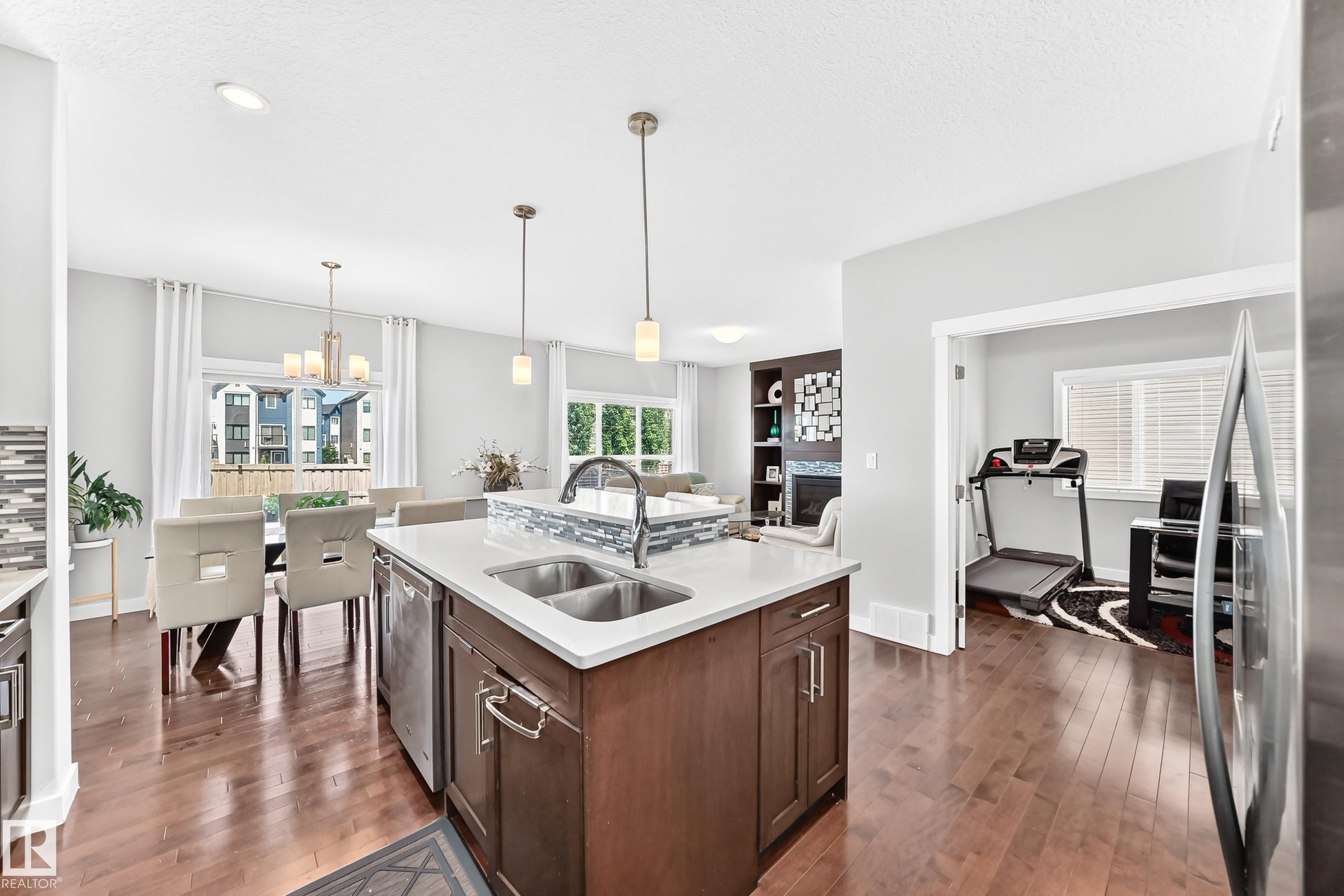 Kitchen island featuring a double-basin sink and an integrated dishwasher - 3672 Claxton Place Sw, Edmonton, AB