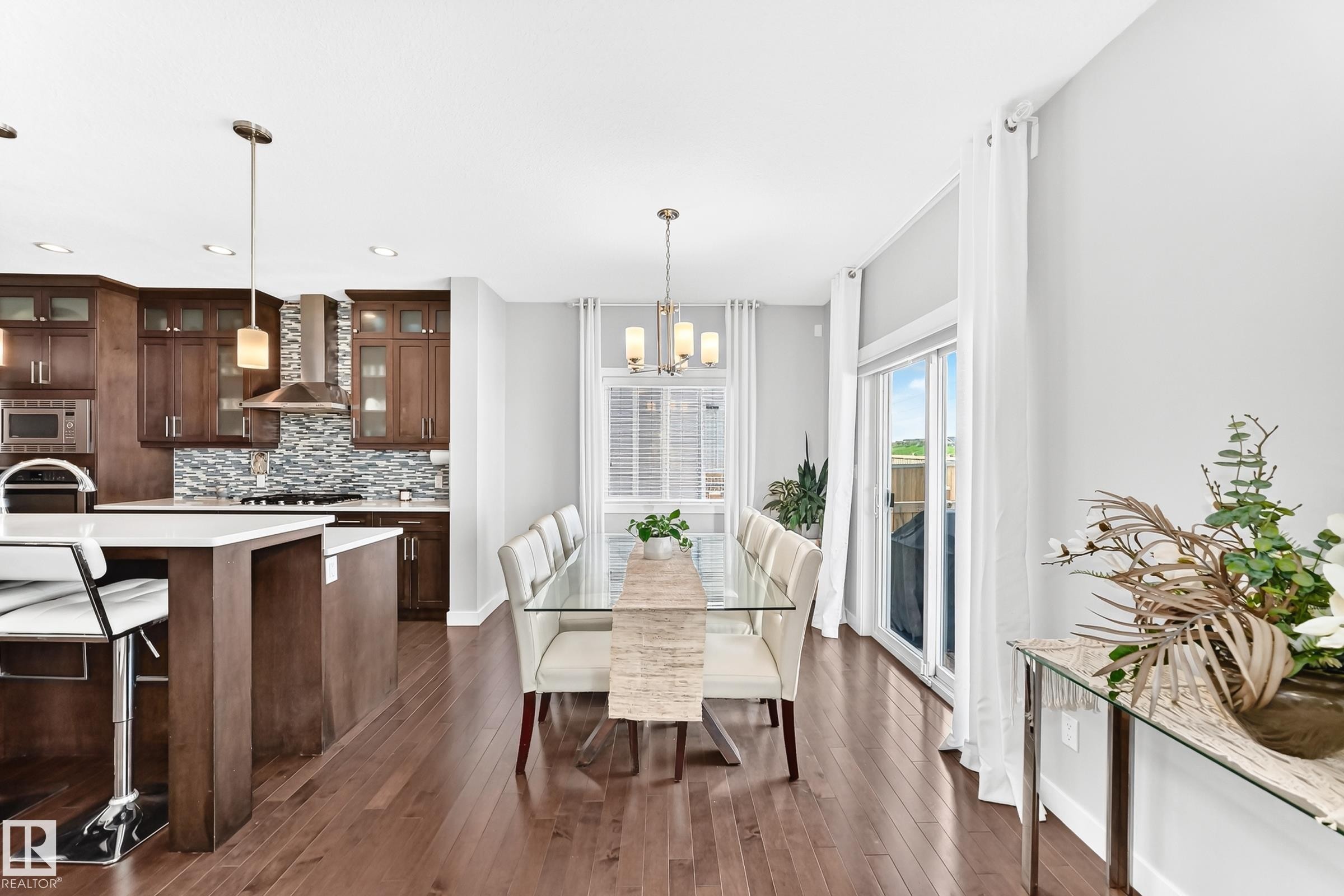 Open-concept kitchen and dining area featuring rich wood-finish flooring - 3672 Claxton Place Sw, Edmonton, AB