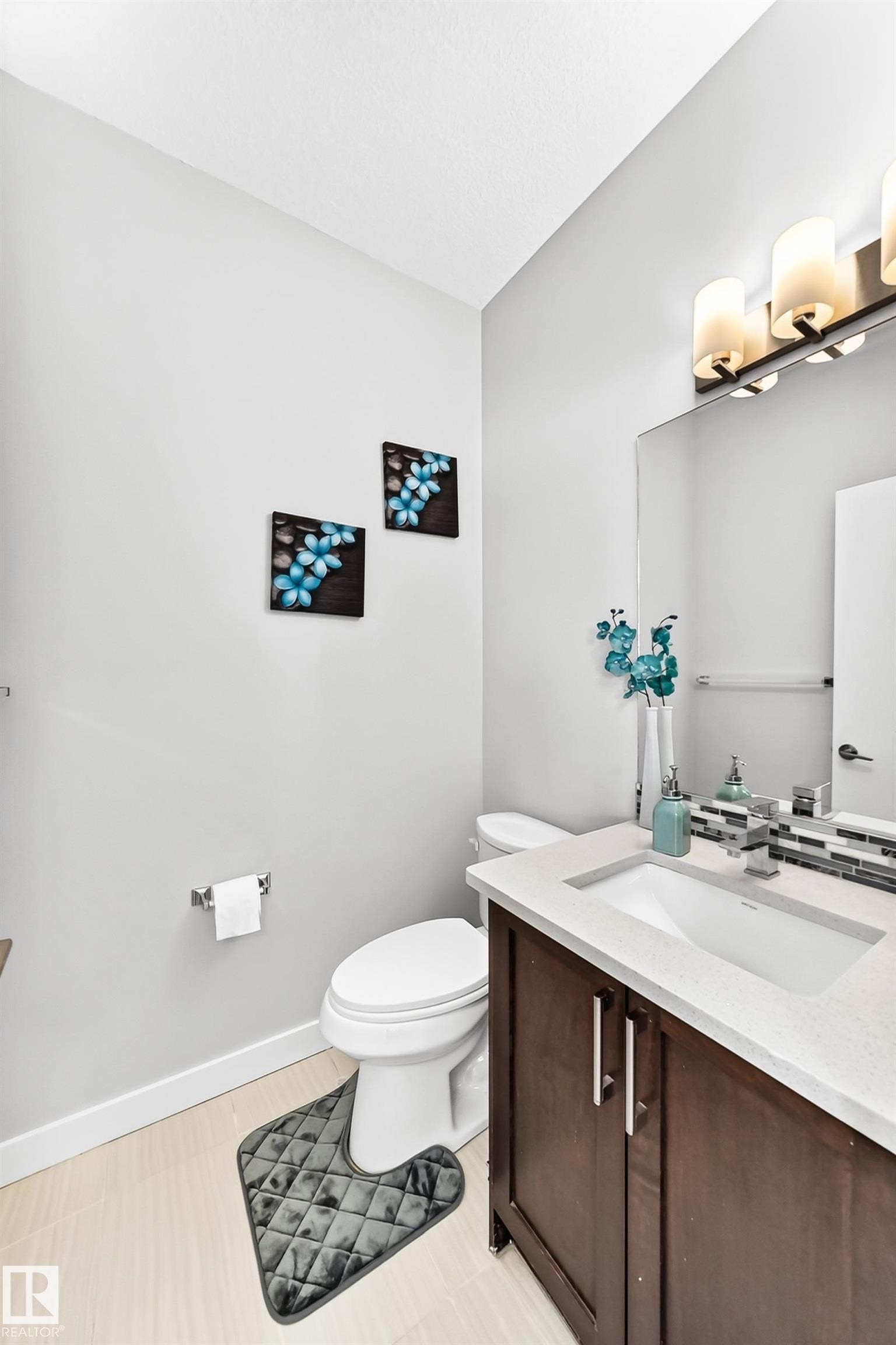 Bathroom vanity with dark wood-finish cabinetry, a white countertop, and an undermount sink - 3672 Claxton Place Sw, Edmonton, AB
