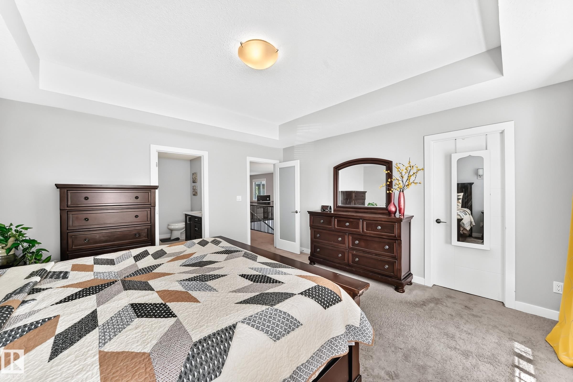 Bedroom featuring light gray wall paint, recessed ceiling with a central flush-mount light fixture, and plush carpet flooring - 3672 Claxton Place Sw, Edmonton, AB
