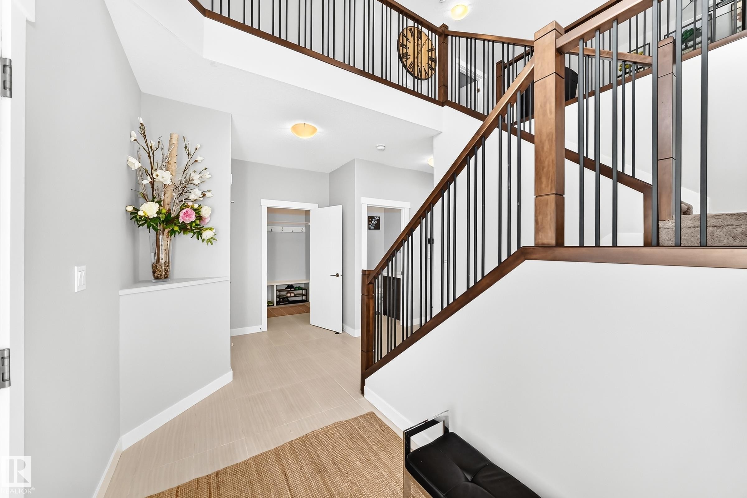 Grand staircase featuring wood-finish handrails and black metal balusters - 3672 Claxton Place Sw, Edmonton, AB