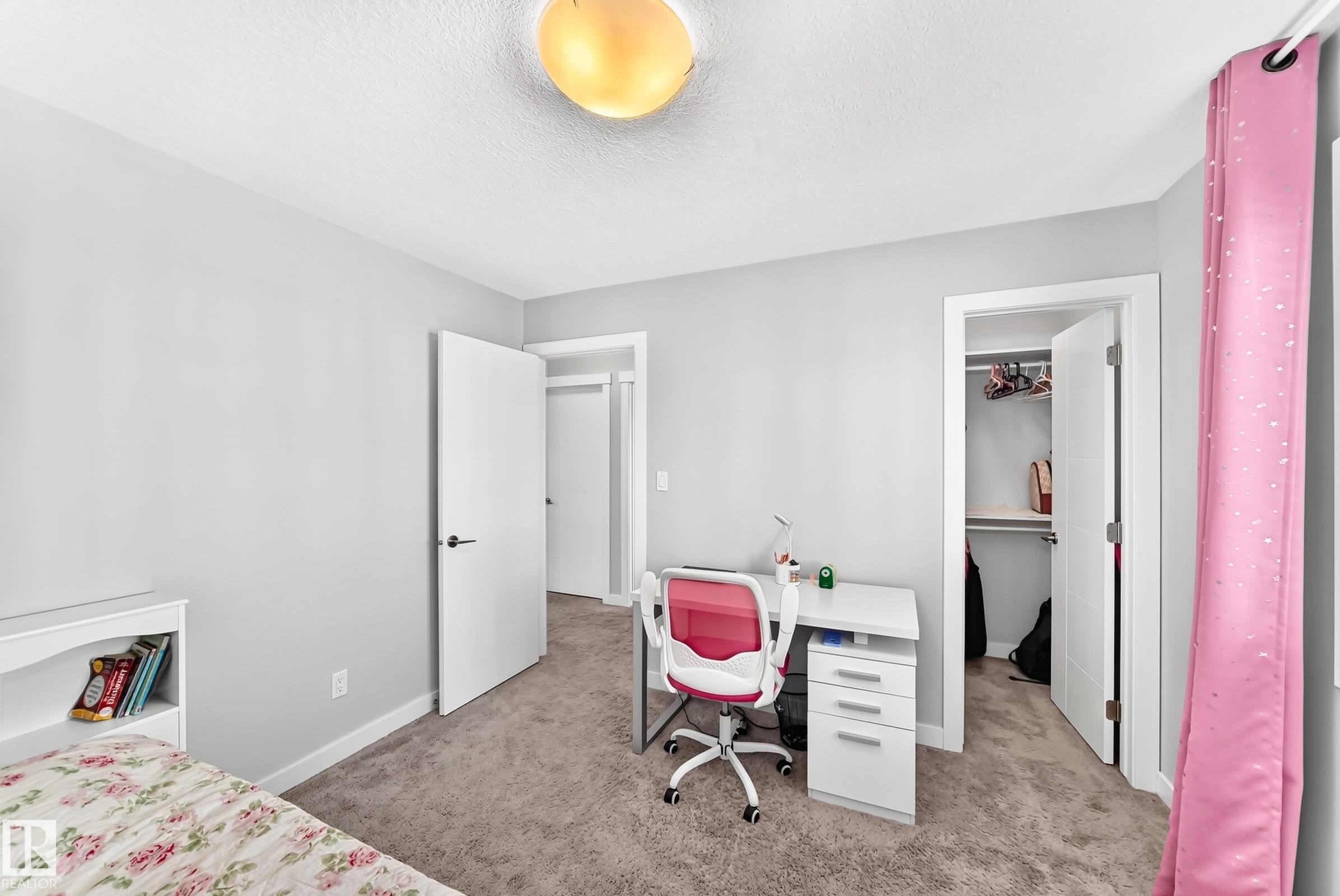 Carpeted bedroom with neutral wall tones, a built-in closet, and white trim throughout - 3672 Claxton Place Sw, Edmonton, AB