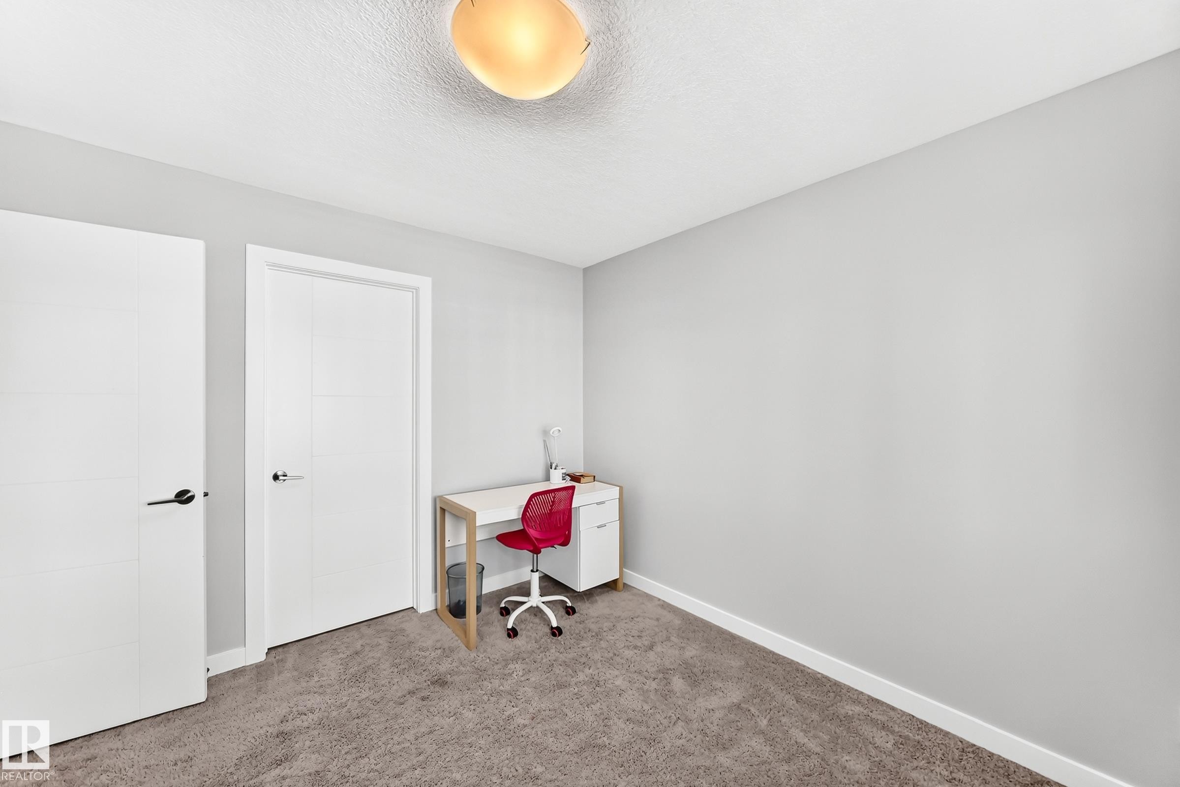 Neutral-toned room featuring a textured ceiling, flush-mount ceiling light, and light gray wall paint - 3672 Claxton Place Sw, Edmonton, AB