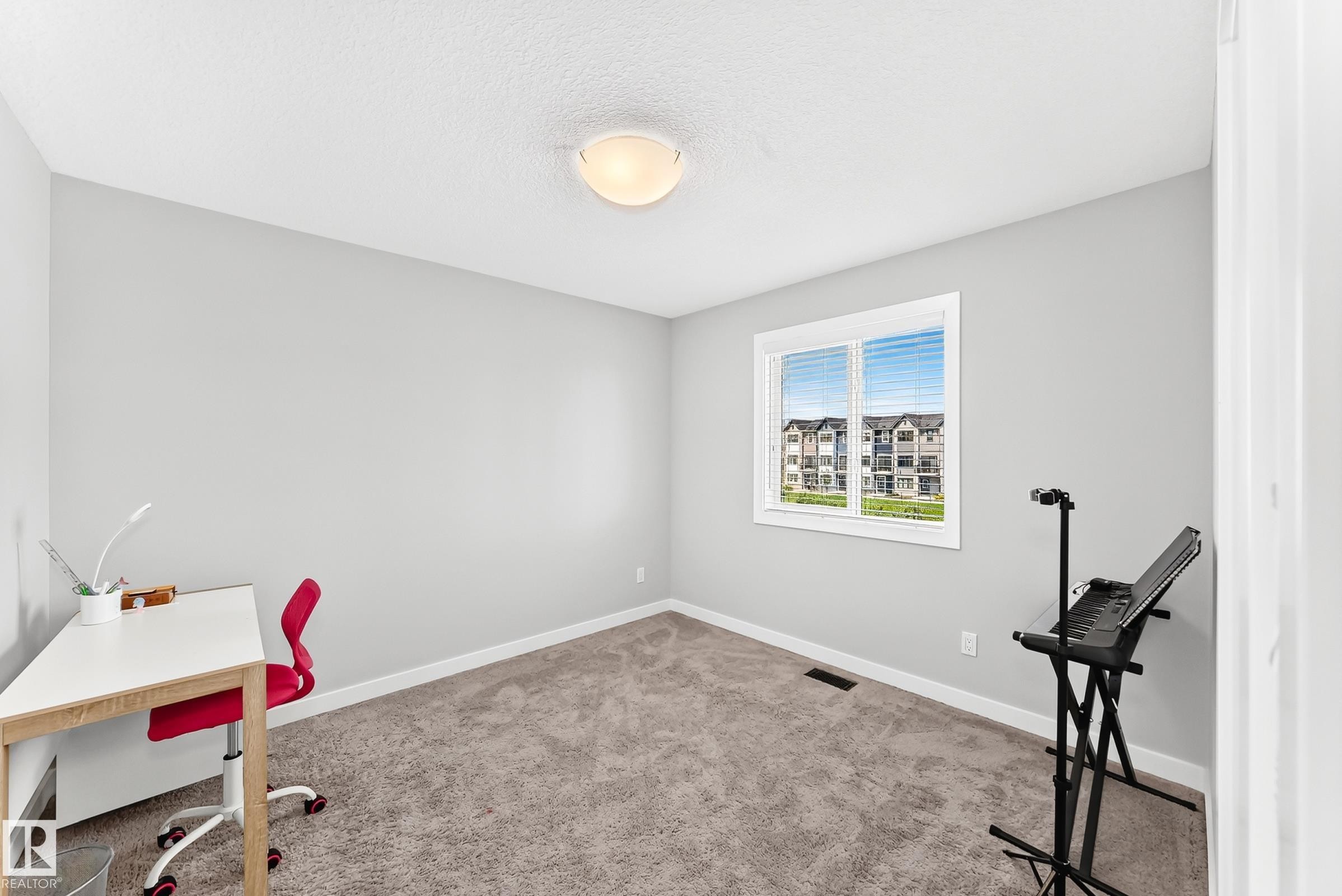Carpeted room with a ceiling light fixture, a single window featuring blinds, and light-toned walls - 3672 Claxton Place Sw, Edmonton, AB