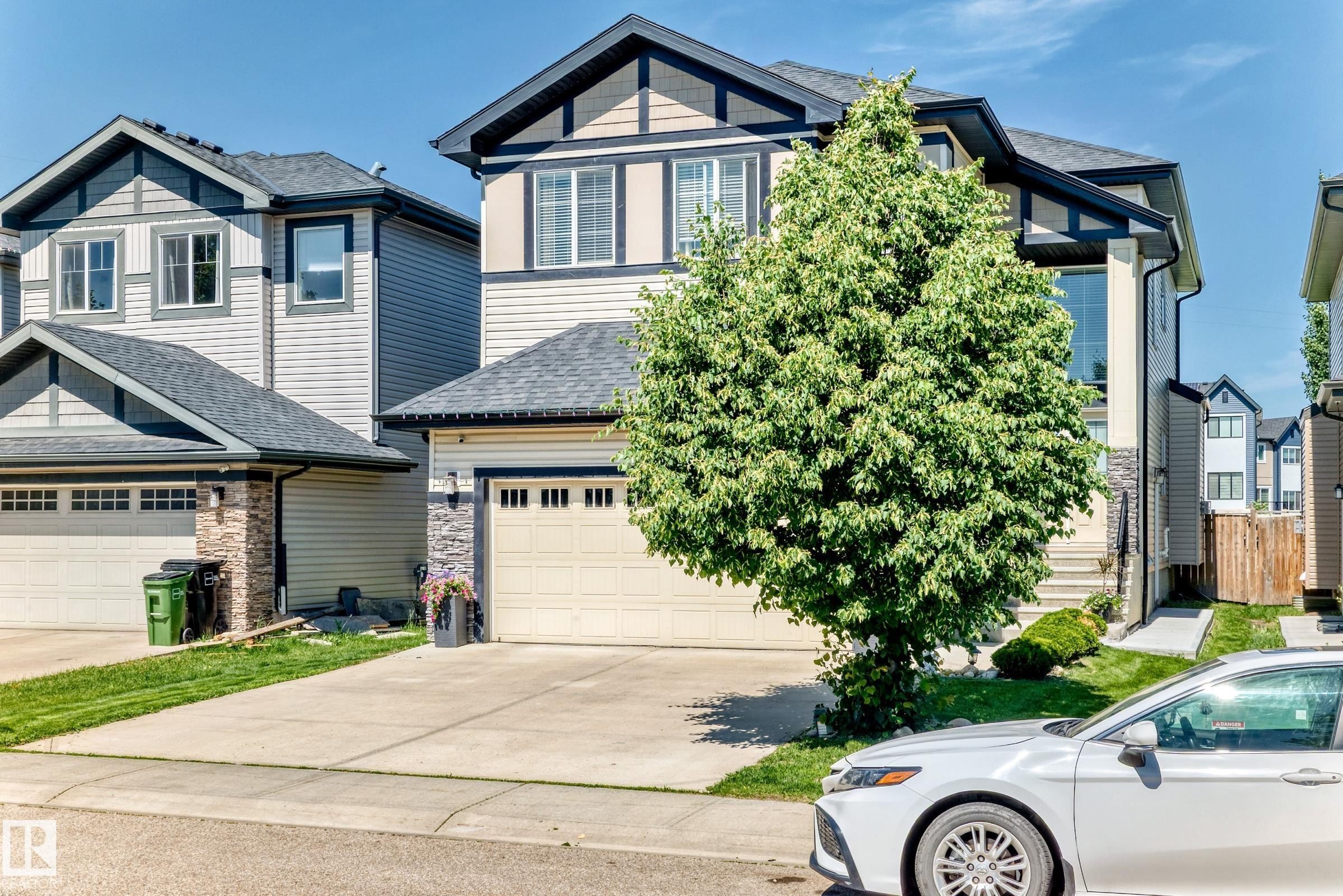 Contemporary two-story residence featuring a prominent front-facing gable, light-toned siding, and dark trim accents - 3672 Claxton Place Sw, Edmonton, AB