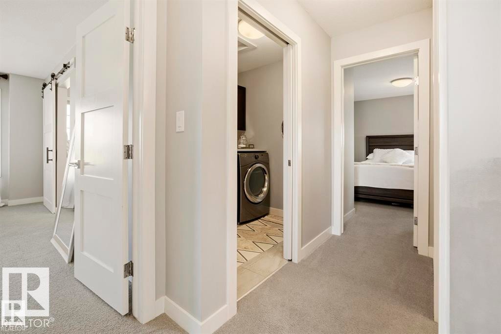 Hallway featuring light gray carpeting, white baseboards, and white interior doors with contemporary hardware - 1004 Huckell Pl Sw, Edmonton, AB - Indoor Photo Showing Other Room