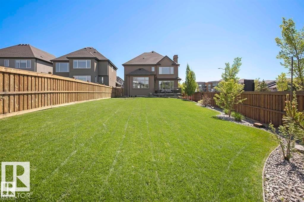 Expansive green lawn with a wooden perimeter fence - 1004 Huckell Pl Sw, Edmonton, AB - Outdoor