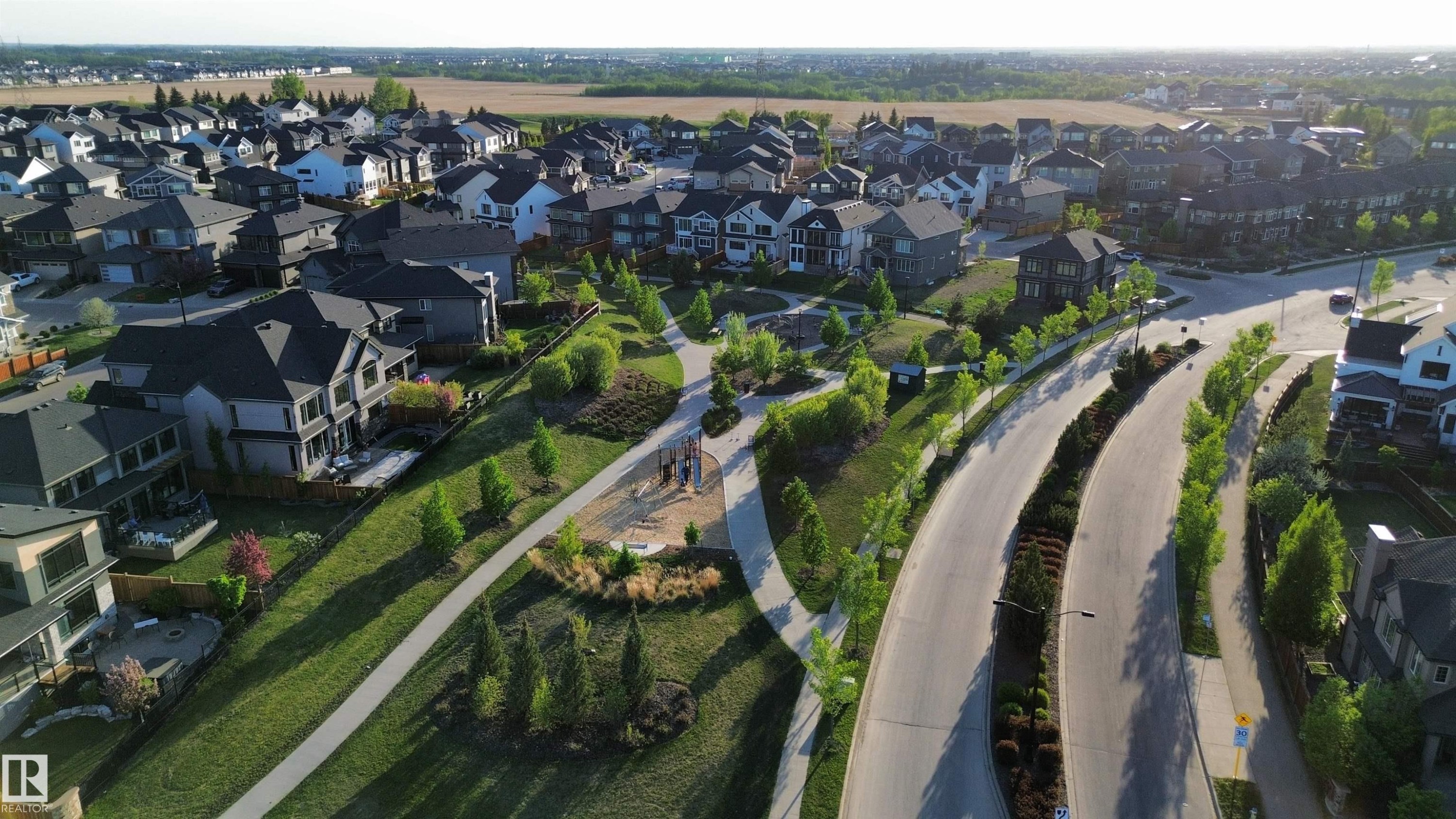 Expansive residential development featuring mature landscaping, paved roadways, and a communal park space - 1004 Huckell Pl Sw, Edmonton, AB - Outdoor With View