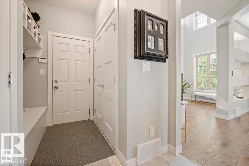 Entryway featuring built-in bench seating with cubby storage, a six-panel door, and an adjacent paneled door - 1004 Huckell Pl Sw, Edmonton, AB - Indoor Photo Showing Other Room