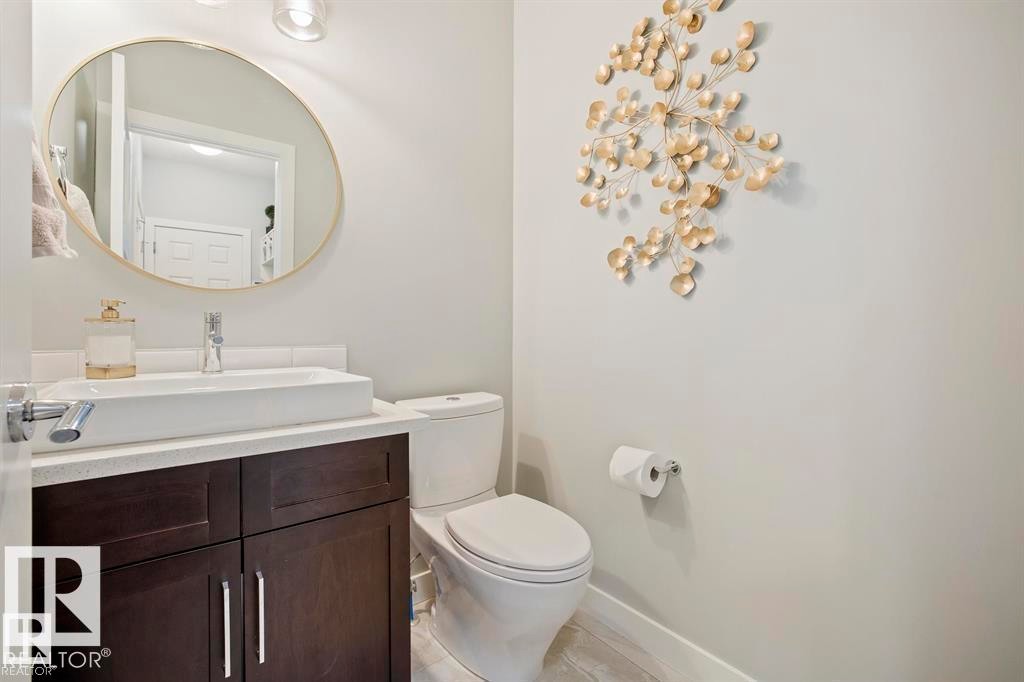 Modern vanity featuring a vessel sink, single-handle chrome faucet, and dark wood-finish cabinetry - 1004 Huckell Pl Sw, Edmonton, AB - Indoor Photo Showing Bathroom