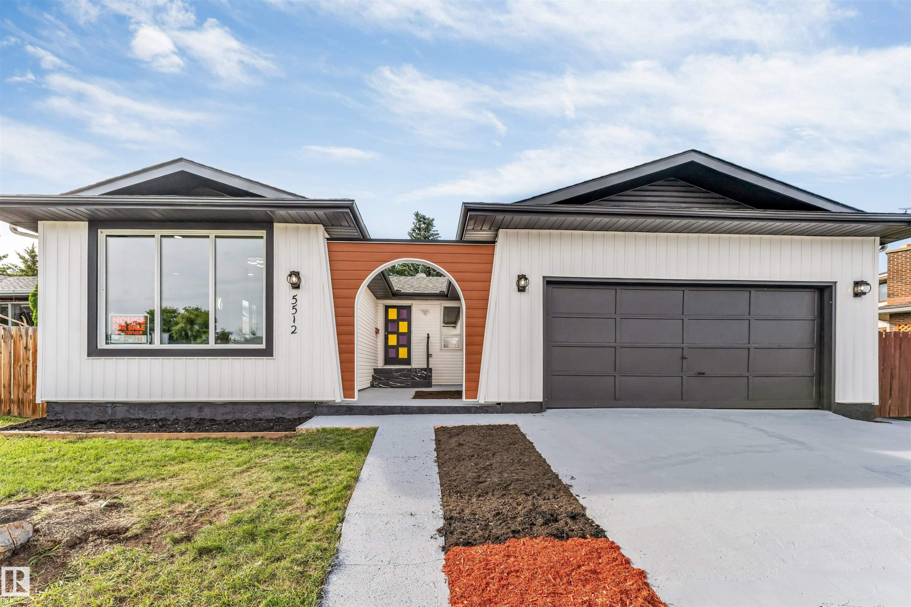 Contemporary exterior featuring white vertical siding, a dark pitched roof, and an integrated garage - 5512 150 Avenue, Edmonton, AB