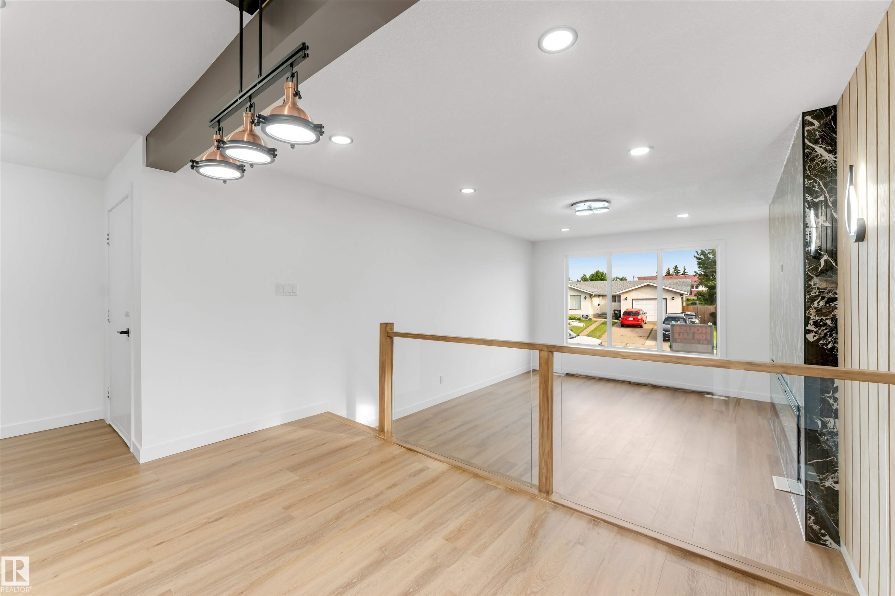Contemporary open-concept interior featuring light wood-finish flooring - 5512 150 Avenue, Edmonton, AB