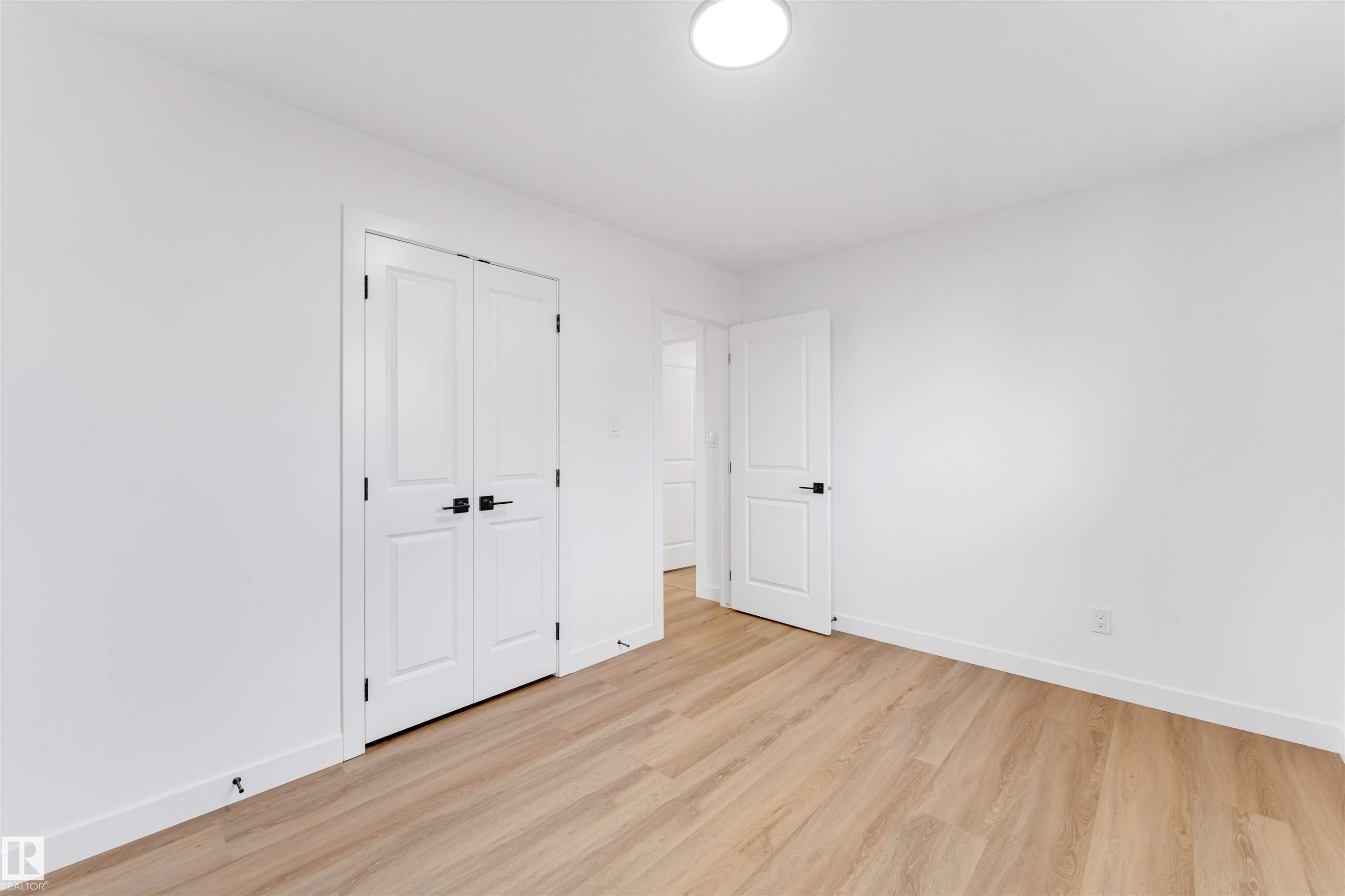 Room featuring light wood-finish flooring, white walls, and white trim - 5512 150 Avenue, Edmonton, AB