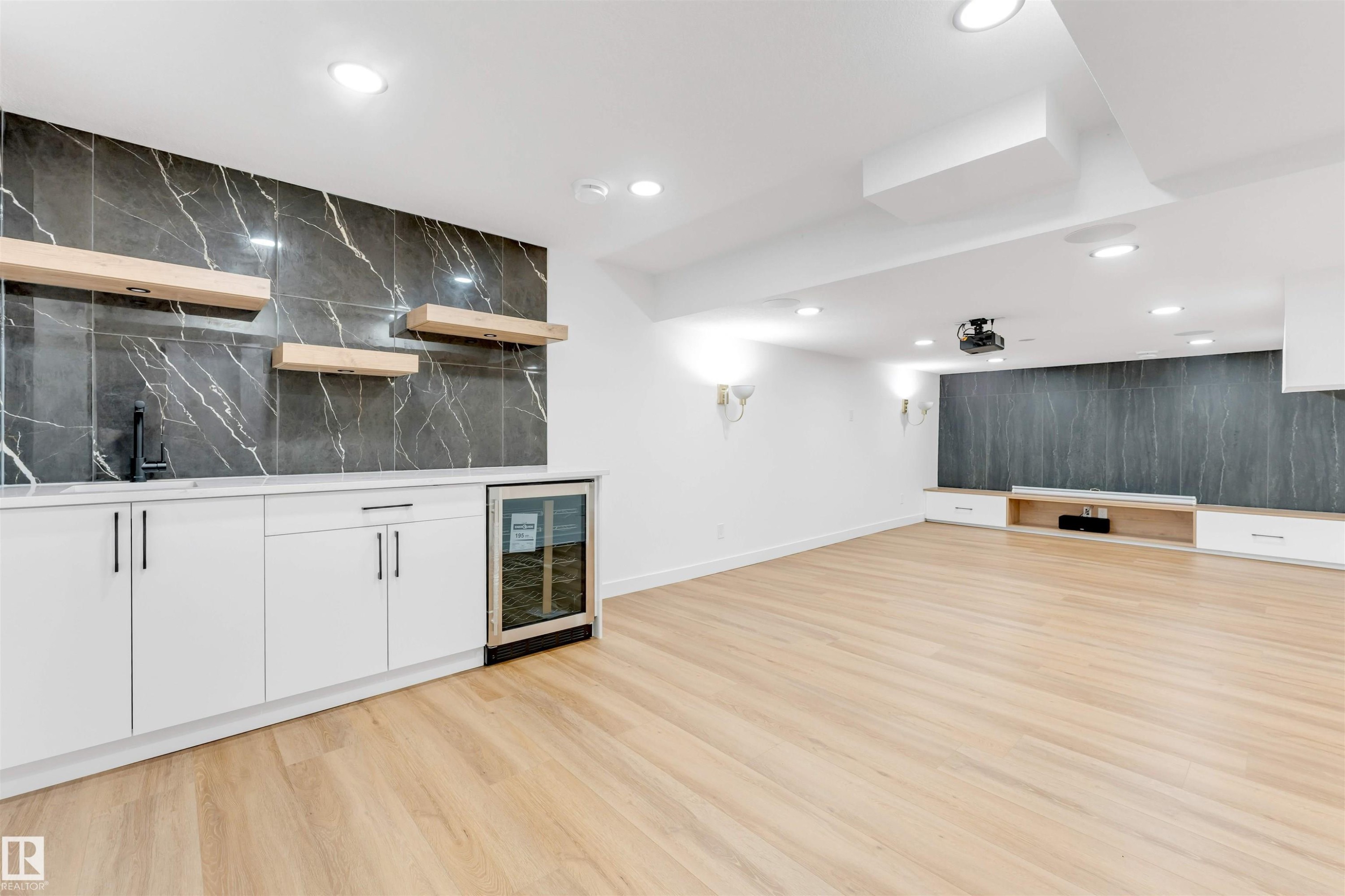 Open-concept space featuring blonde wood-finish flooring and recessed lighting - 5512 150 Avenue, Edmonton, AB