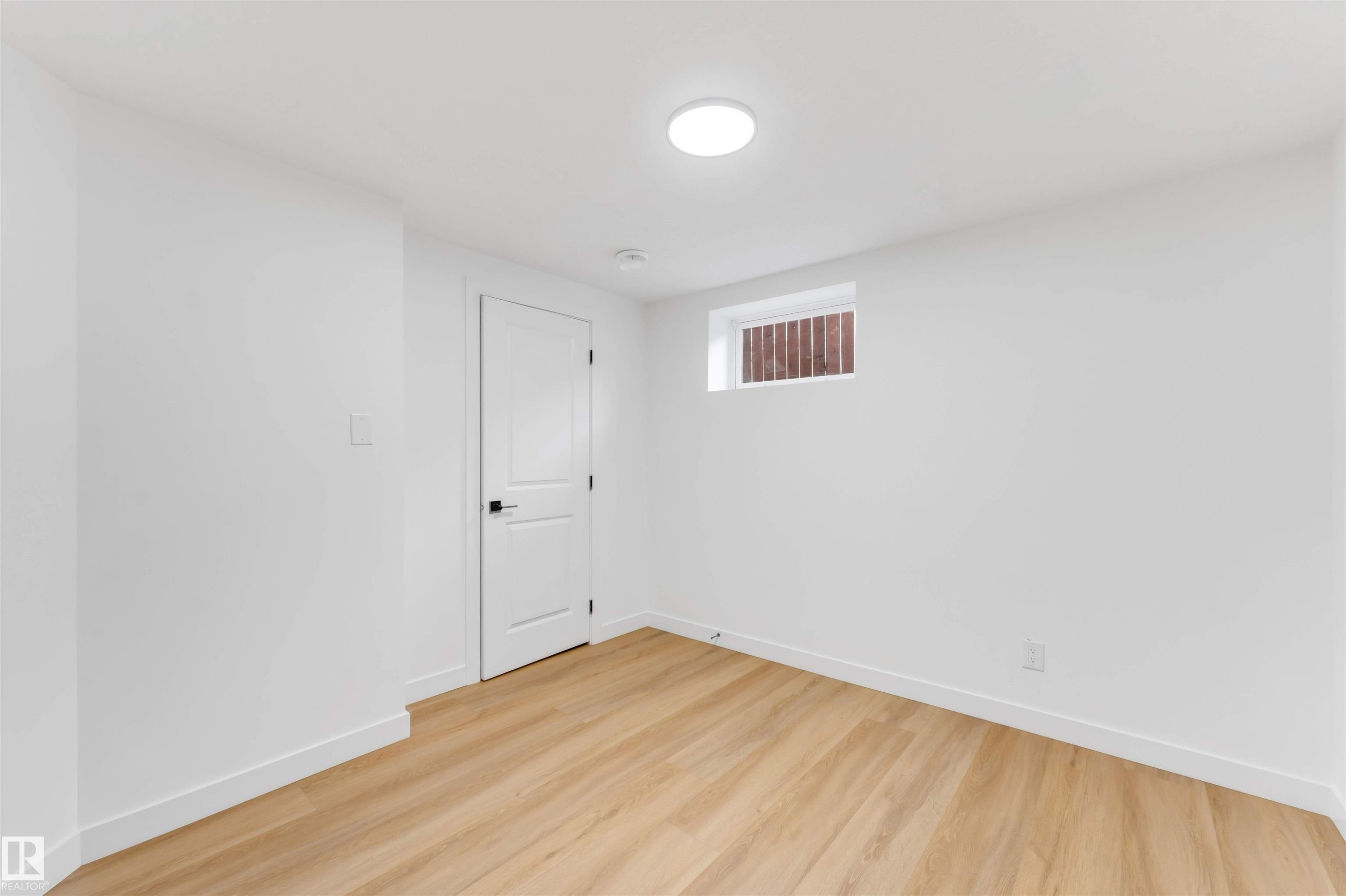 Room featuring light wood-finish flooring, white painted walls, and white baseboards - 5512 150 Avenue, Edmonton, AB