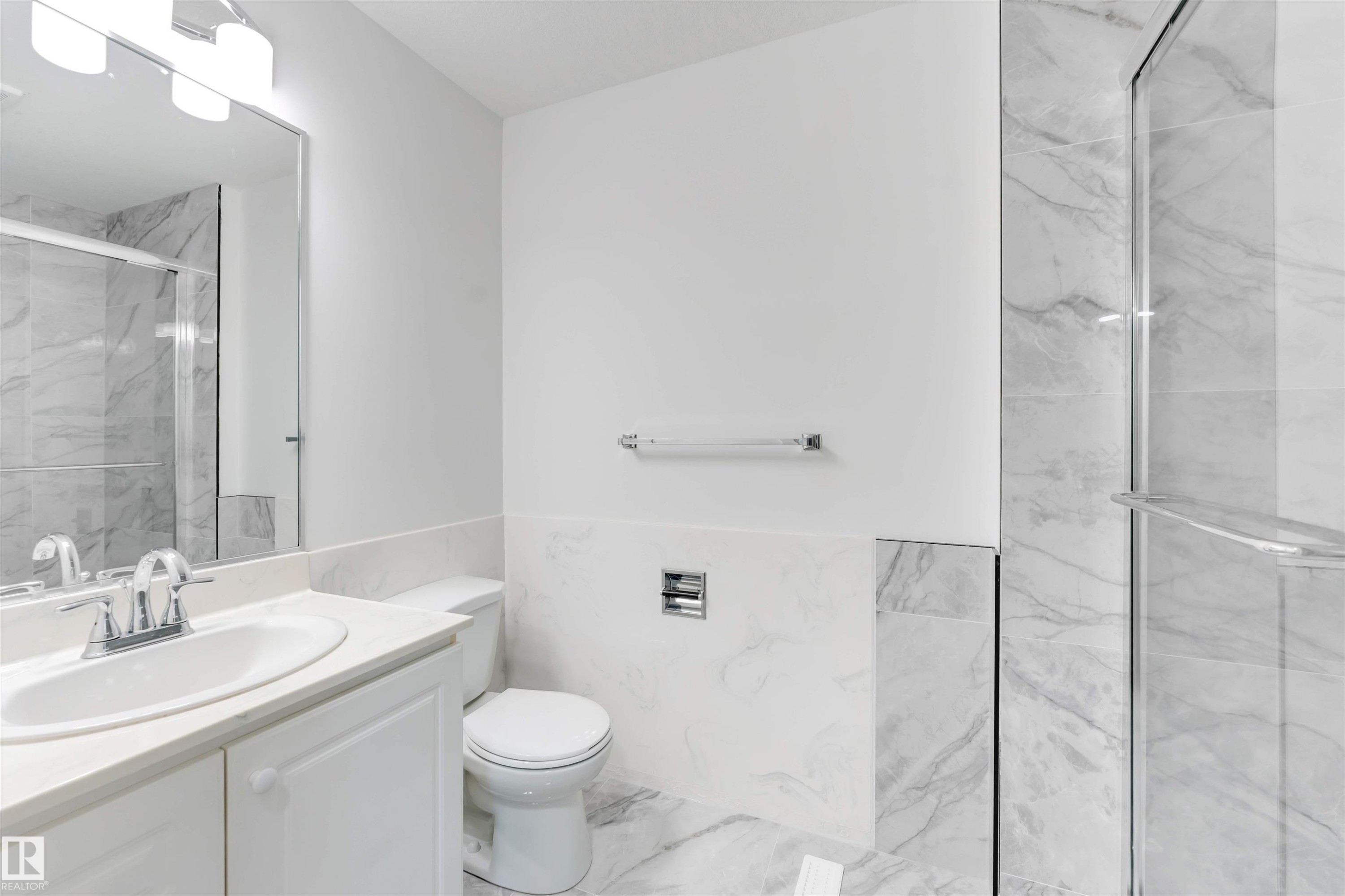 Contemporary bathroom featuring a white vanity with an integrated sink, polished chrome faucet, and a large wall-mounted mirror - 5512 150 Avenue, Edmonton, AB