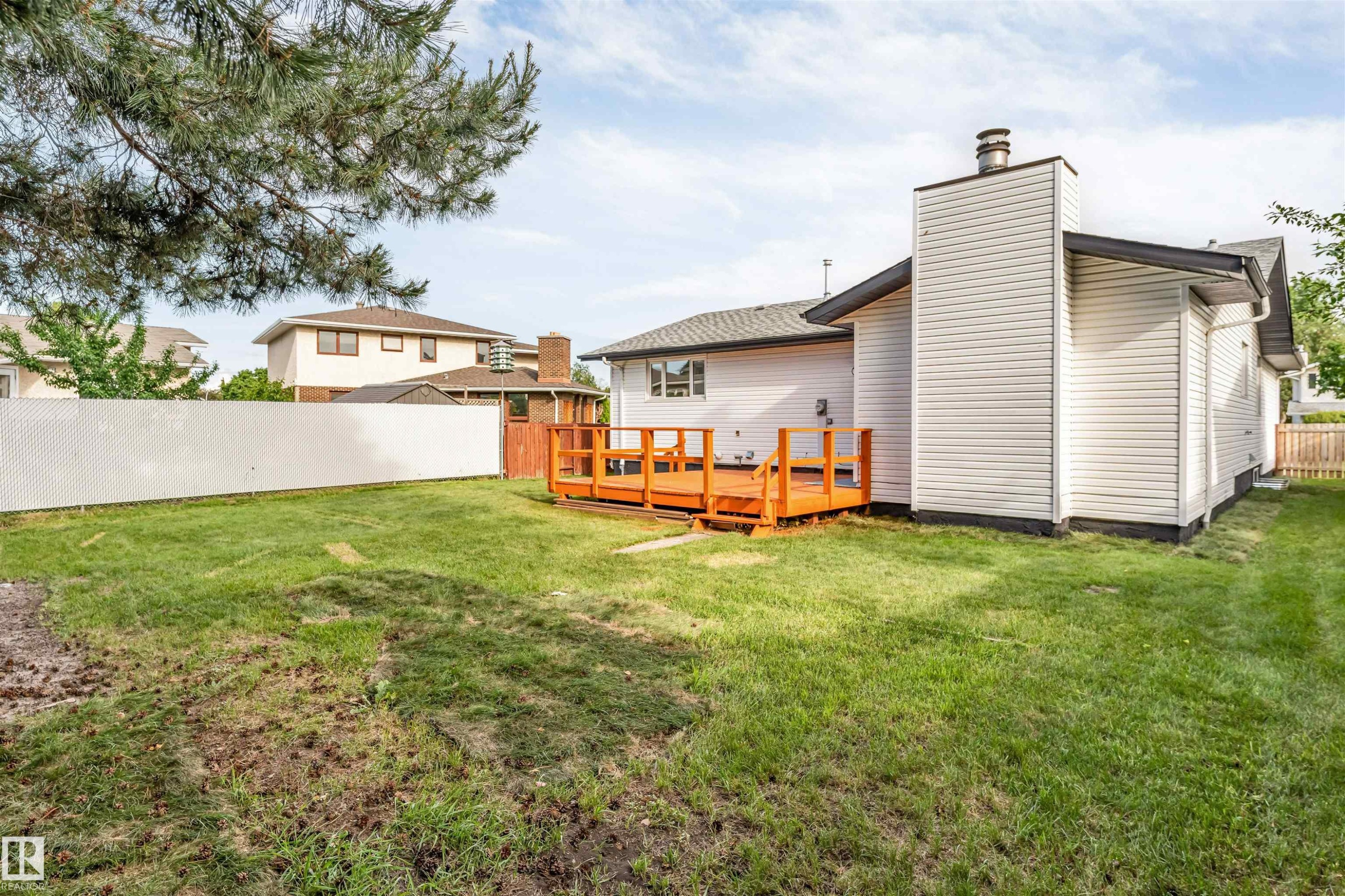 Expansive green lawn with a white lattice fence - 5512 150 Avenue, Edmonton, AB