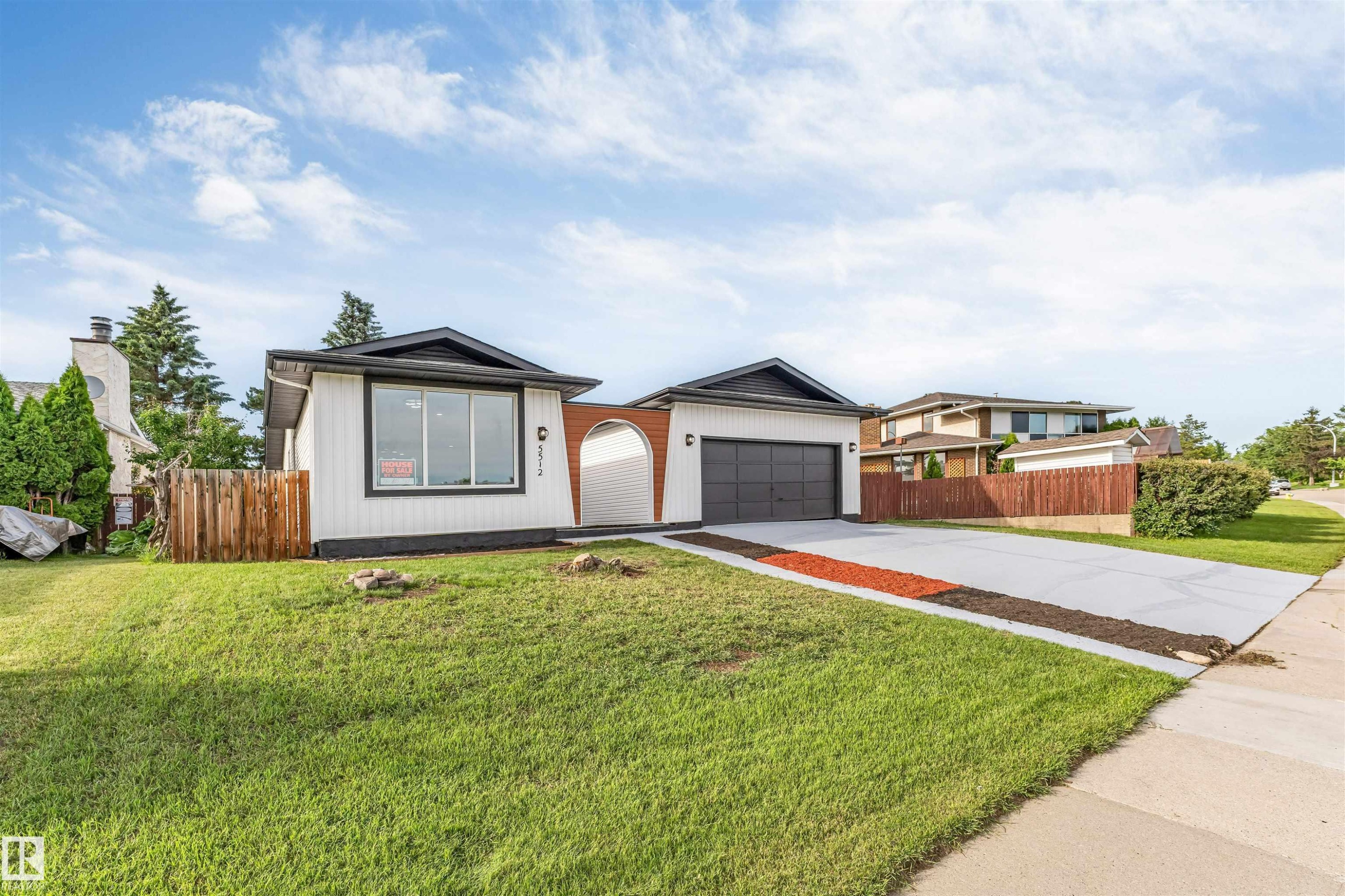 Contemporary ranch-style residence featuring white siding and a prominent dark roofline - 5512 150 Avenue, Edmonton, AB