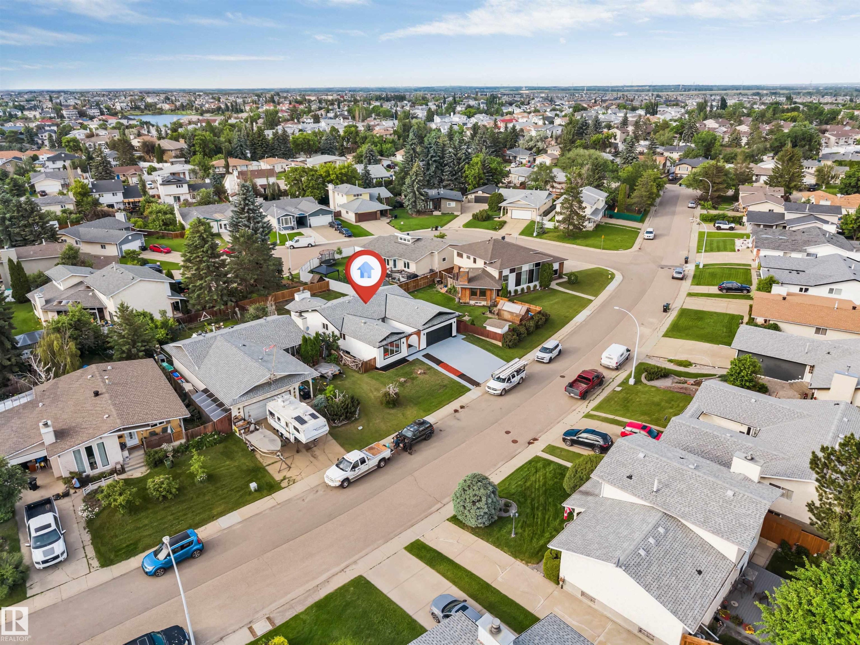 Aerial view of a residential neighborhood featuring detached homes with grey shingle roofs and landscaped yards - 5512 150 Avenue, Edmonton, AB