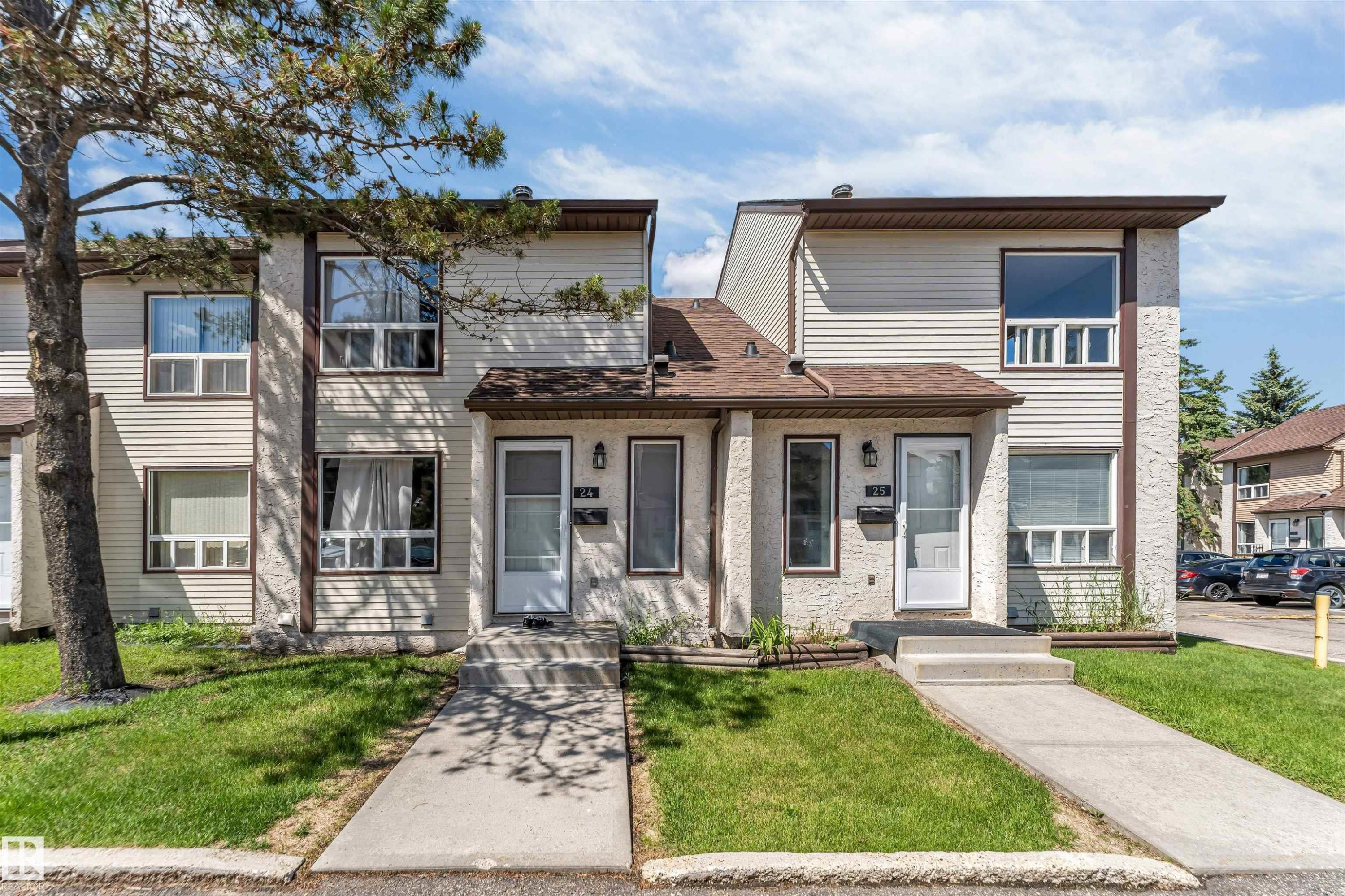 Two-story townhouse exterior with light siding and textured stucco accents - 24 1651 46 Street, Edmonton, AB