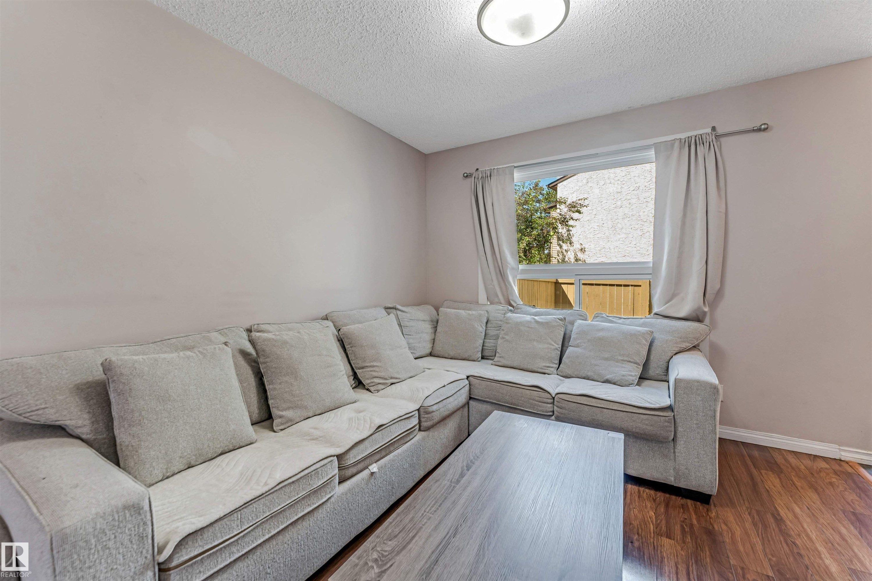 Living area with wood-finish flooring and light-toned walls - 24 1651 46 Street, Edmonton, AB