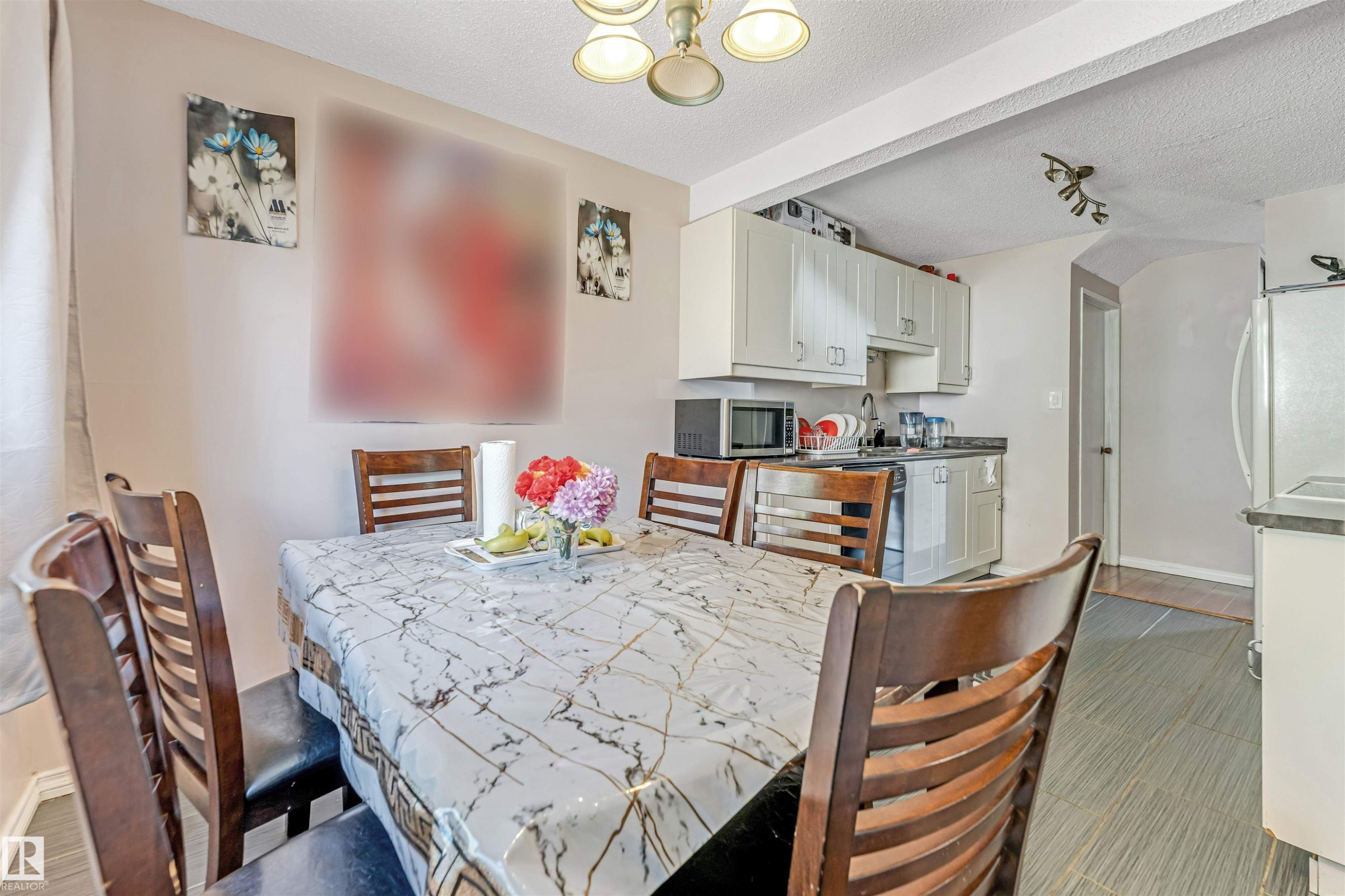 Dining area with an open concept to the kitchen featuring a built-in chandelier - 24 1651 46 Street, Edmonton, AB