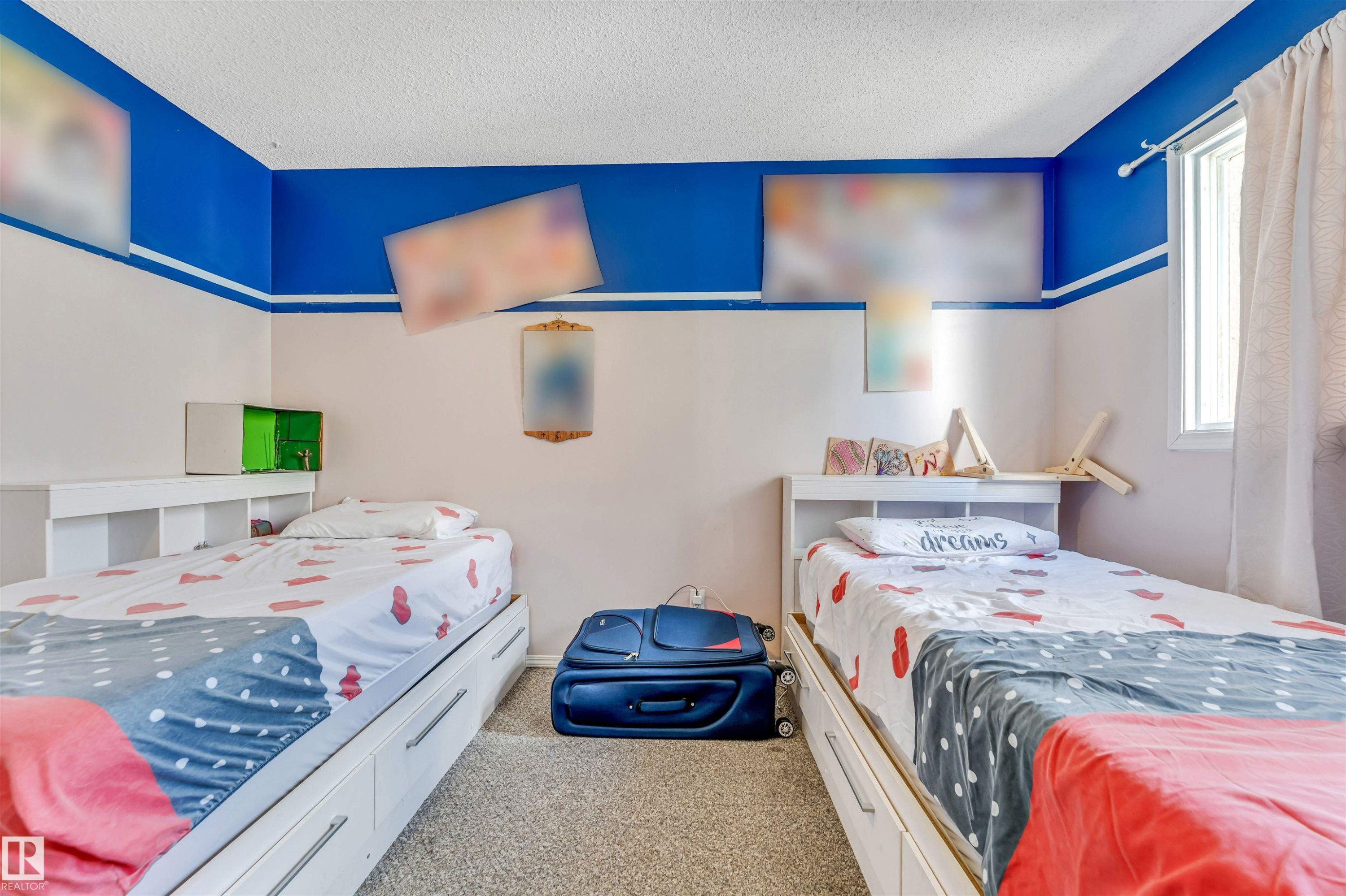 Carpeted room featuring two built-in storage beds with integrated shelving, a window with natural light, and a two-tone wall design - 24 1651 46 Street, Edmonton, AB