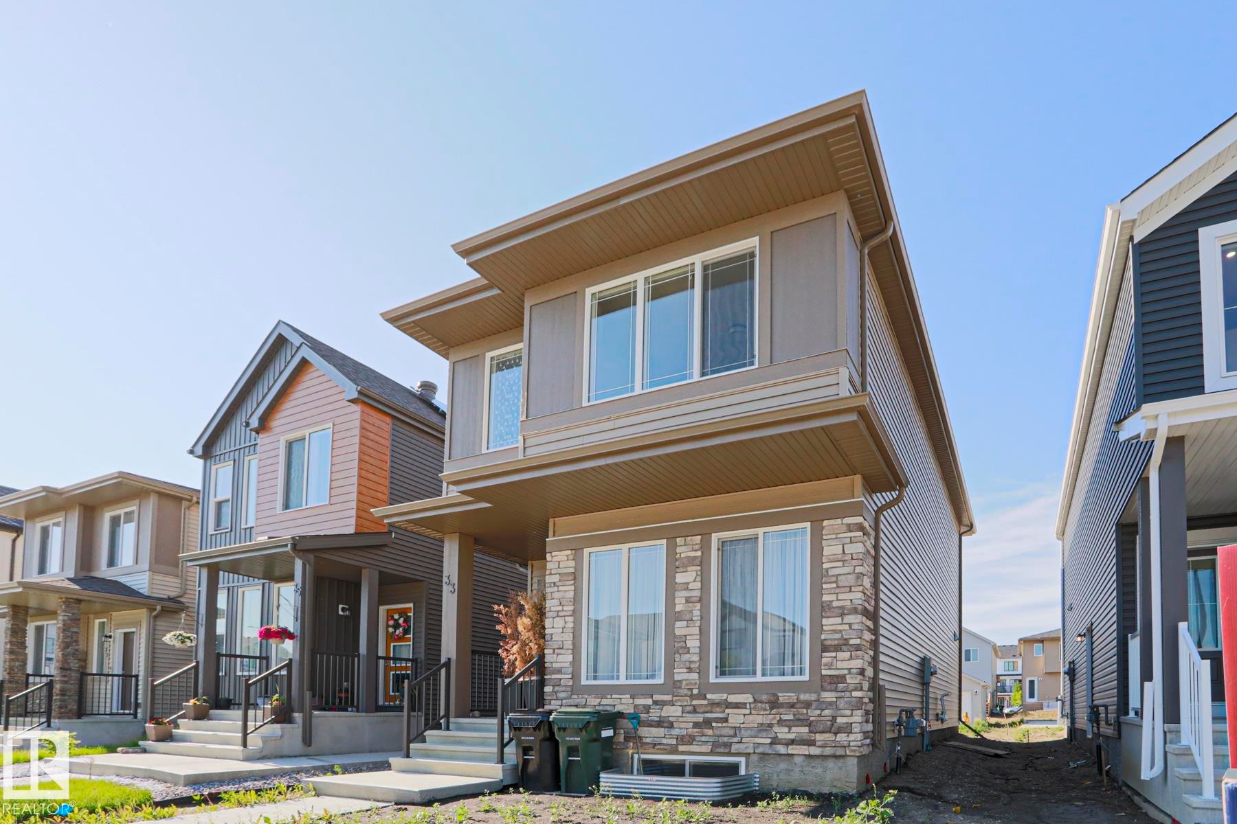 Contemporary two-story residence featuring a stone veneer facade on the lower level - 33 Eton Link, Spruce Grove, AB