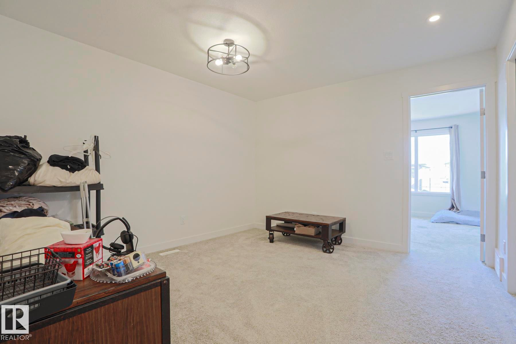 Bright interior space featuring light-colored carpeting and white wall finishes - 33 Eton Link, Spruce Grove, AB