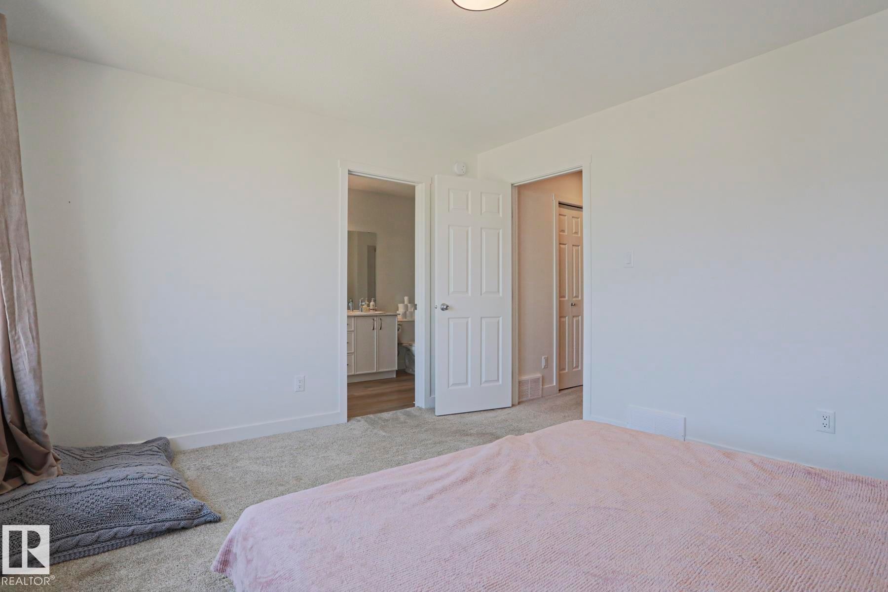 Bedroom featuring light-colored carpeting and white walls - 33 Eton Link, Spruce Grove, AB
