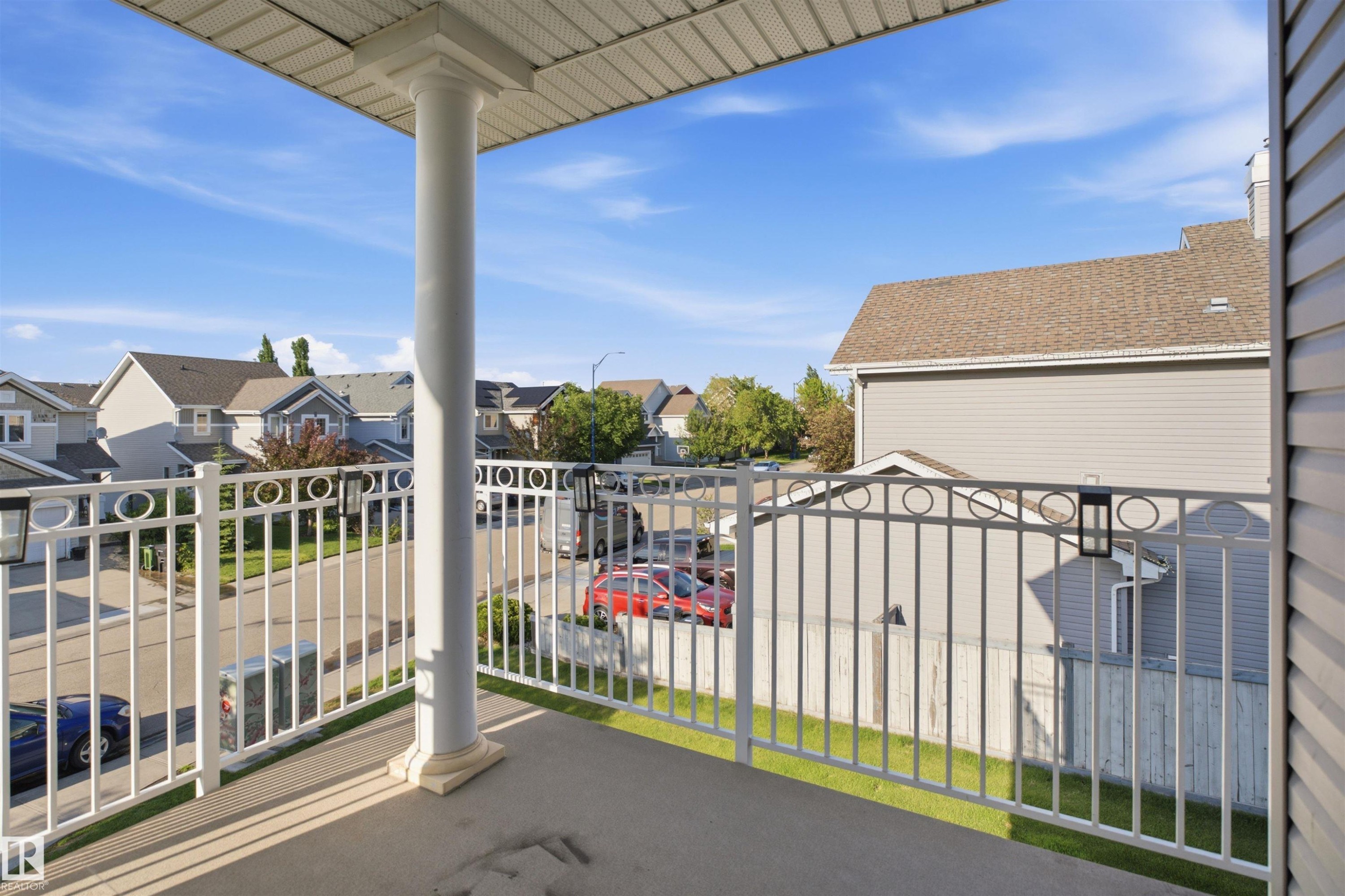 Private balcony featuring a concrete surface, white painted railings with decorative circles, and an overhead soffit - 95 3040 Spence Wynd, Edmonton, AB