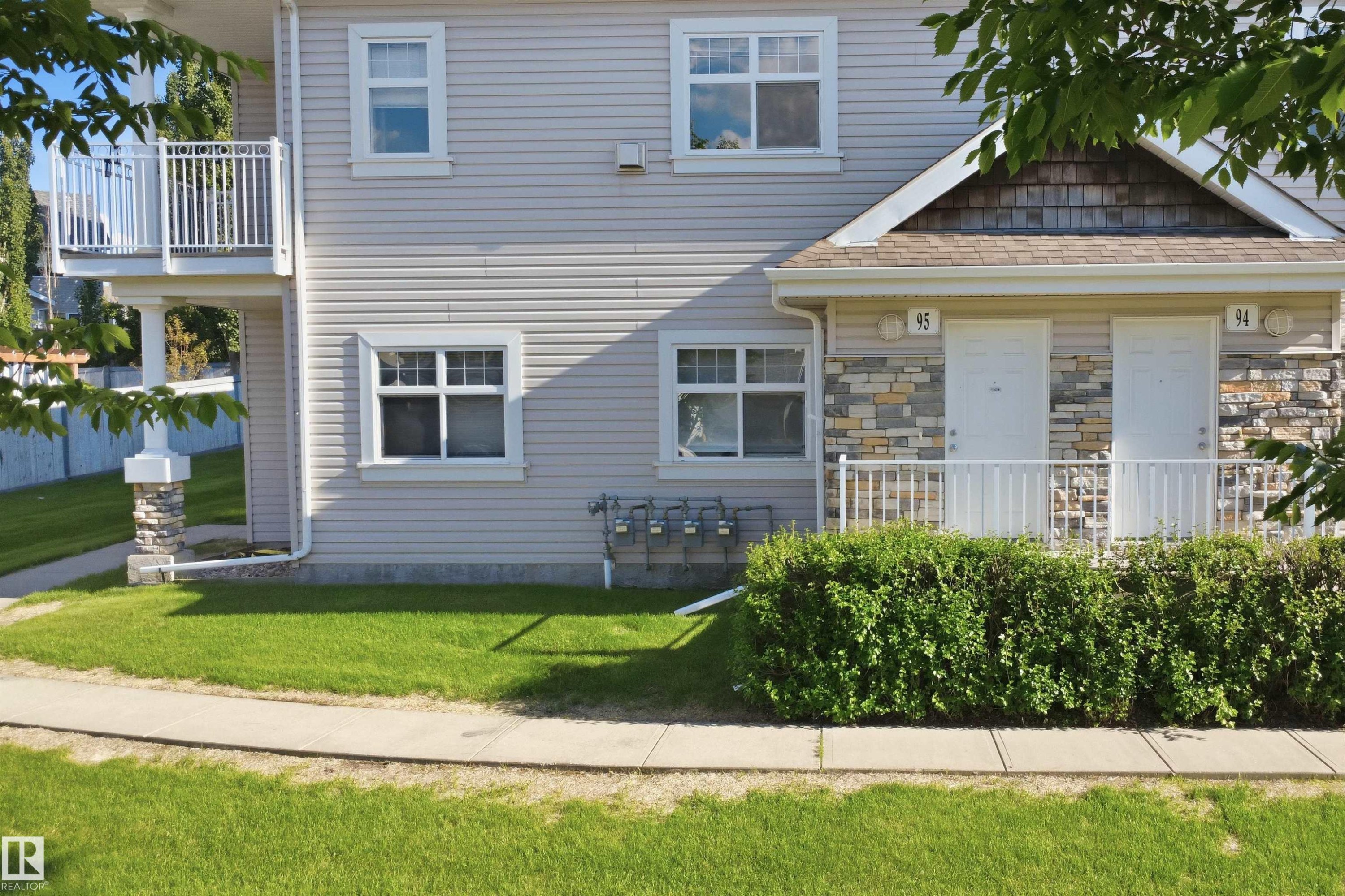 Exterior featuring light-toned horizontal siding with stone accents - 95 3040 Spence Wynd, Edmonton, AB