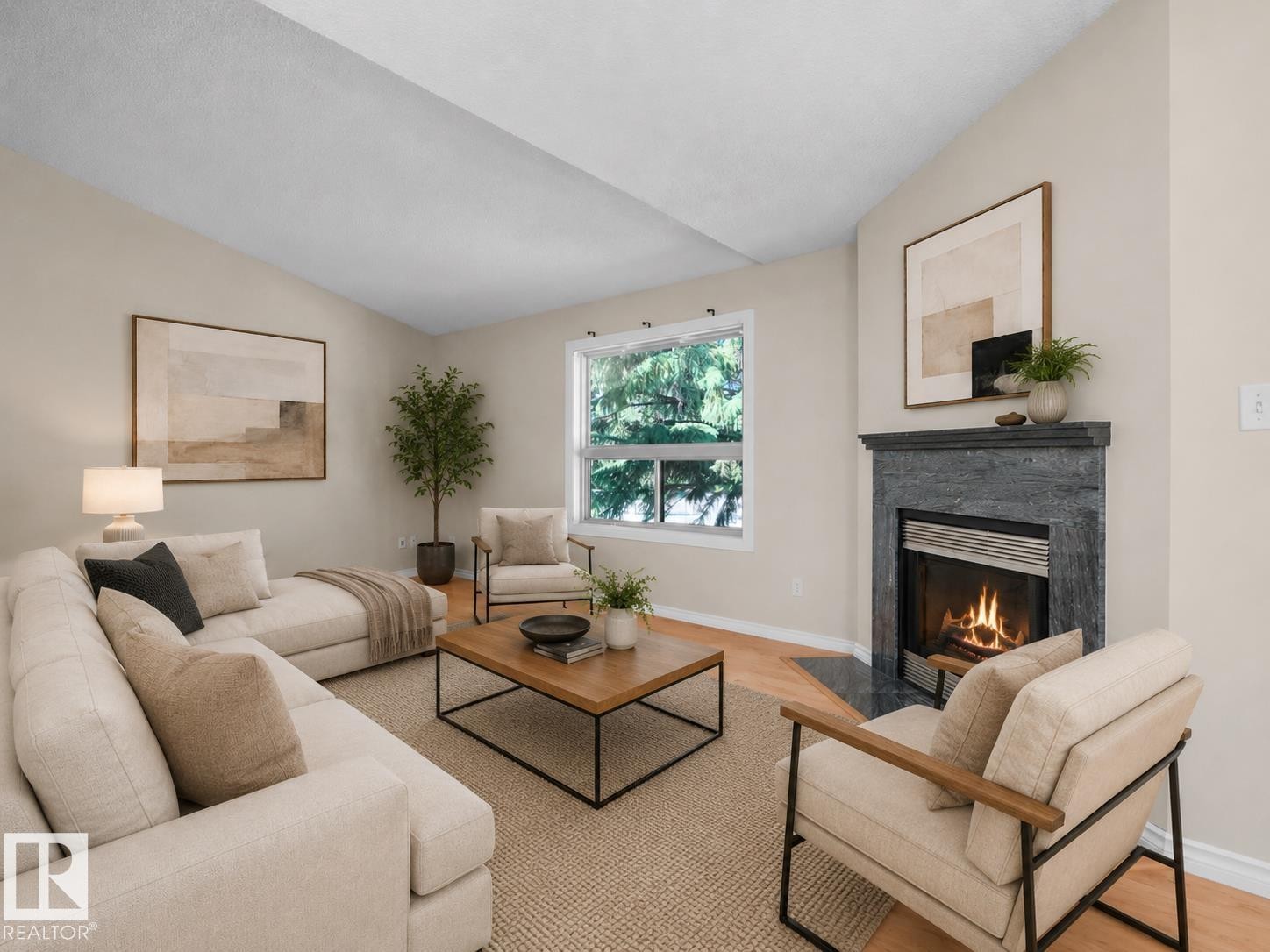 Living area featuring a gas fireplace with a dark stone surround and hearth, vaulted ceiling, and hardwood-style flooring - 1855 Mill Woods Rd E Nw, Edmonton, AB