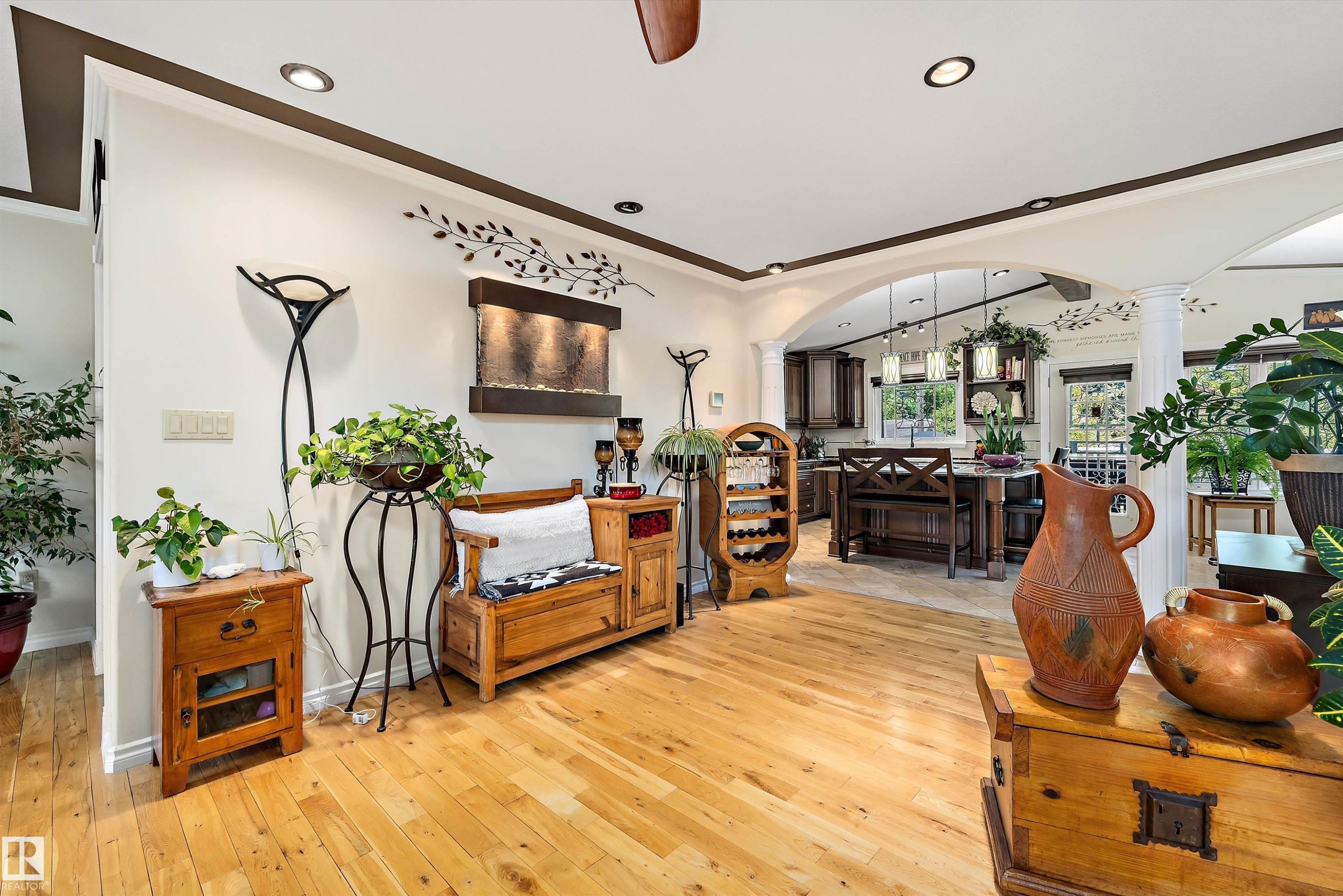 Spacious interior featuring wood-finish flooring, recessed lighting, and an arched entry to the kitchen - 11124 110A Avenue Nw, Edmonton, AB