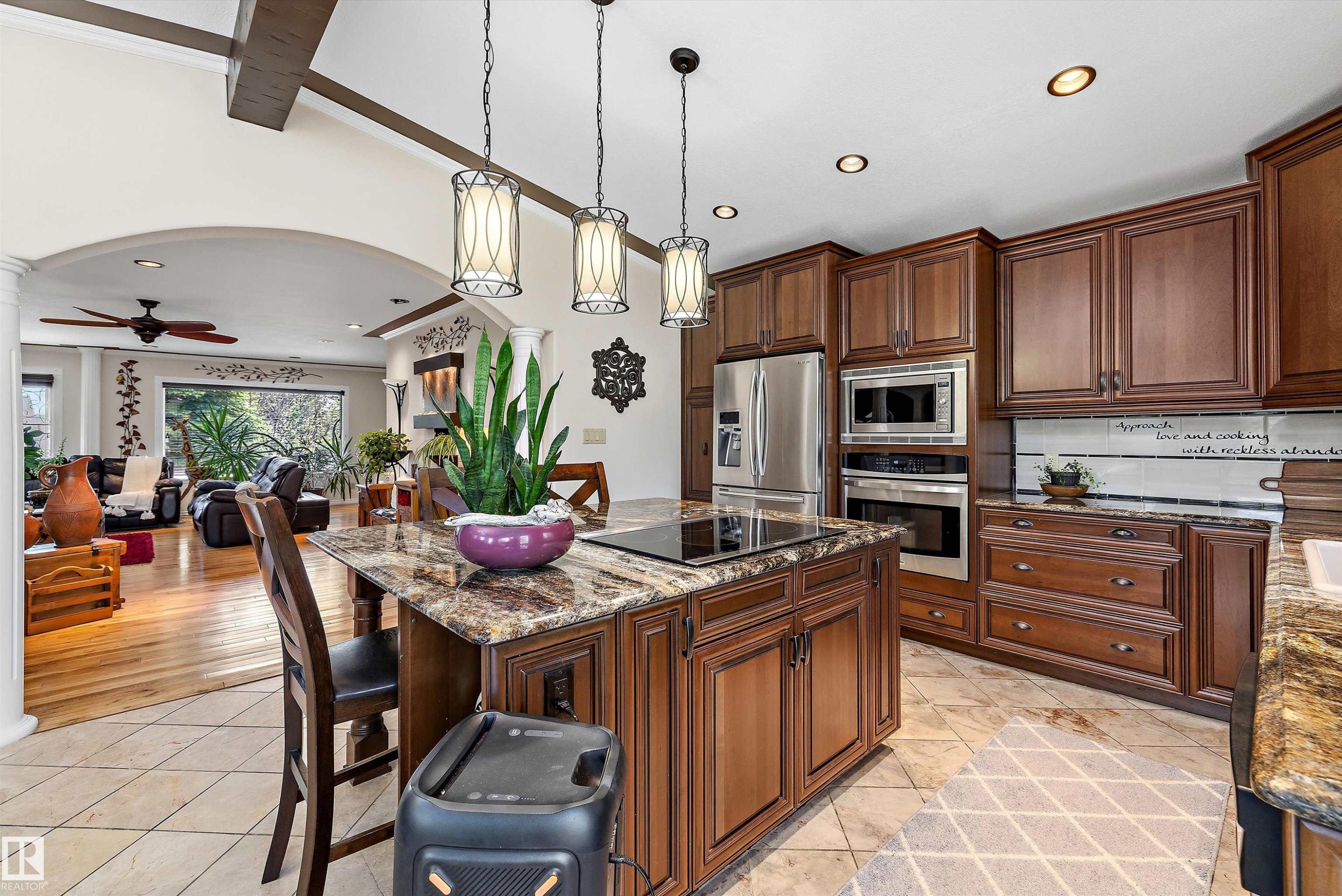 Kitchen island featuring a cooktop, granite countertop, and pendant lighting - 11124 110A Avenue Nw, Edmonton, AB