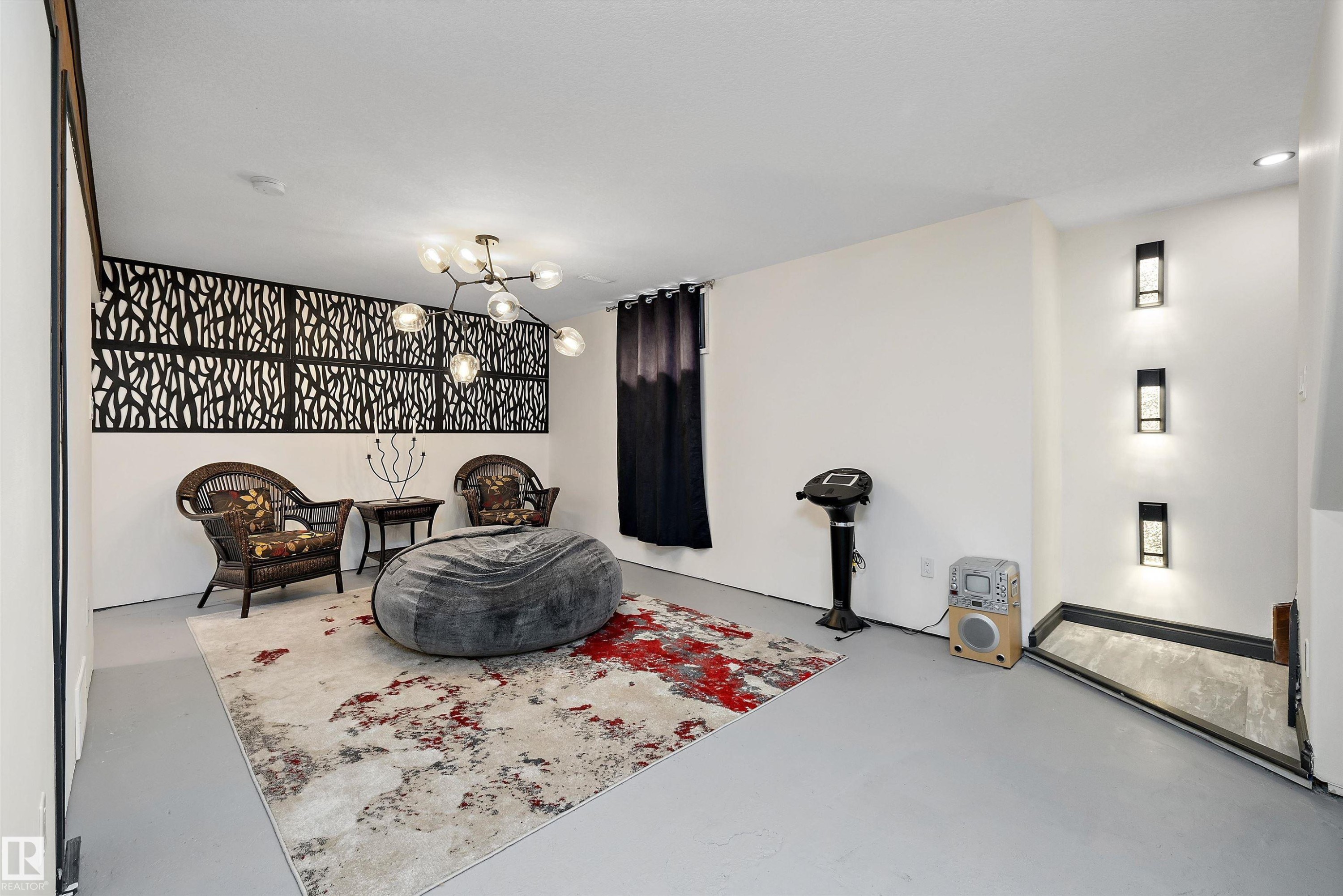 Spacious room featuring a contemporary chandelier, decorative wall panels, recessed lighting, and light-toned flooring - 11124 110A Avenue Nw, Edmonton, AB