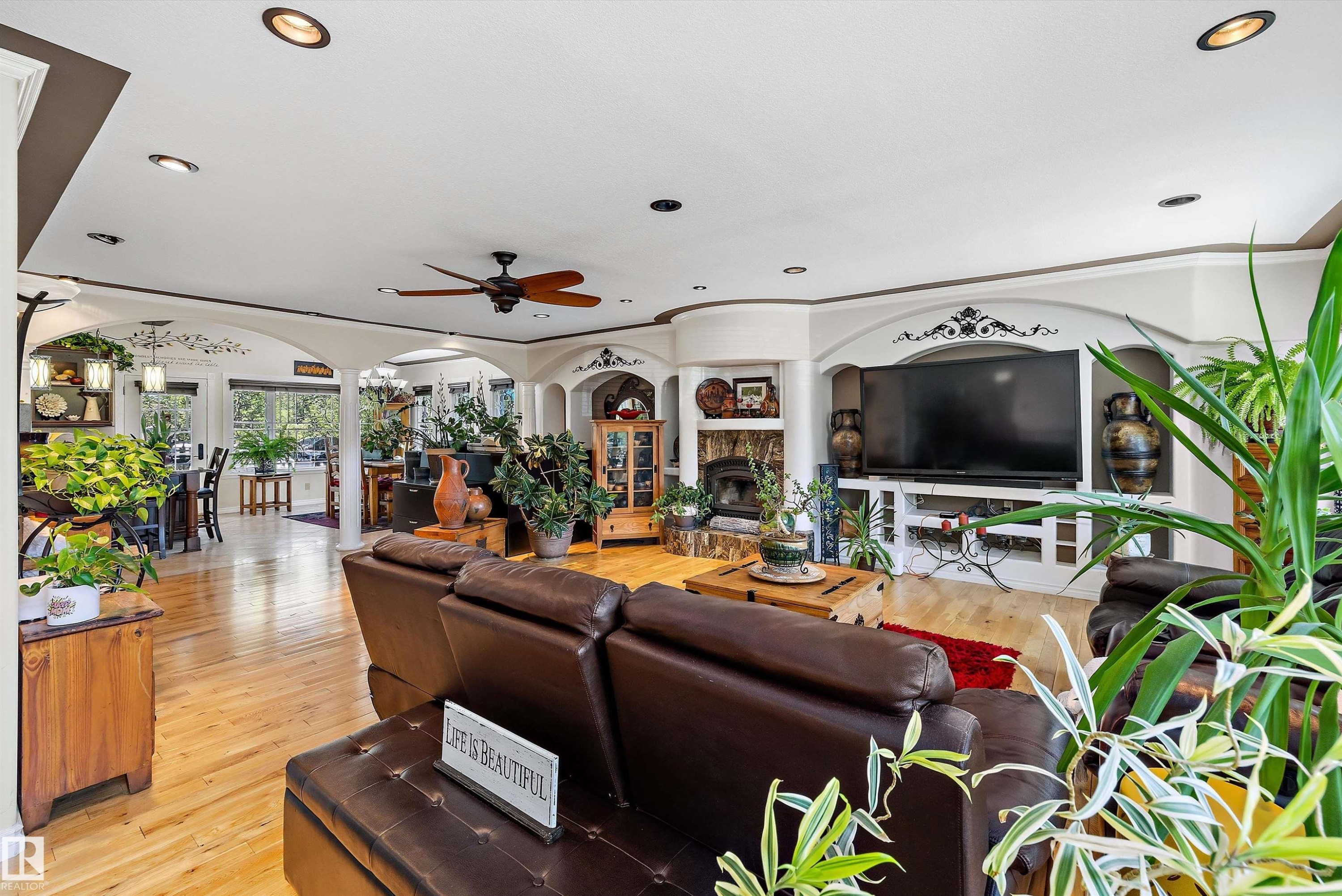 Spacious living area featuring wood-finish flooring, recessed lighting, and a ceiling fan - 11124 110A Avenue Nw, Edmonton, AB