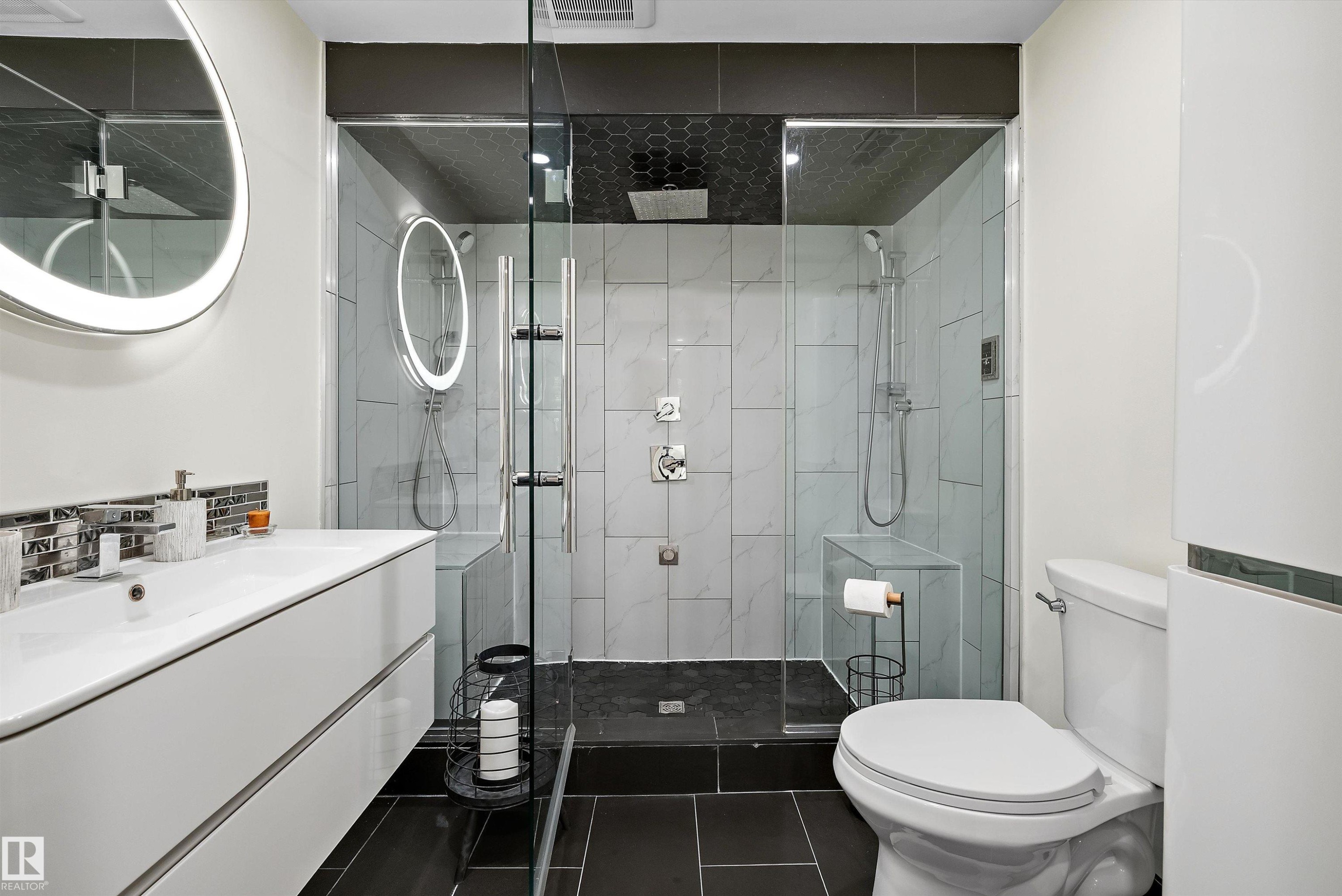 Modern bathroom featuring a glass-enclosed shower with two shower heads, a built-in shower bench, and dark hexagonal tile ceiling - 11124 110A Avenue Nw, Edmonton, AB