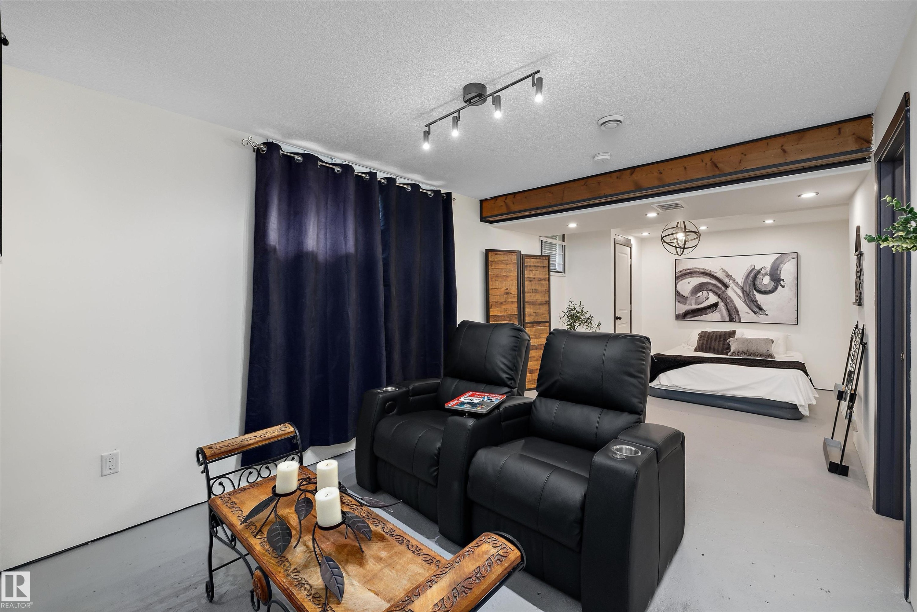 Spacious interior featuring a decorative exposed wood beam, recessed lighting, and a contemporary spherical light fixture - 11124 110A Avenue Nw, Edmonton, AB