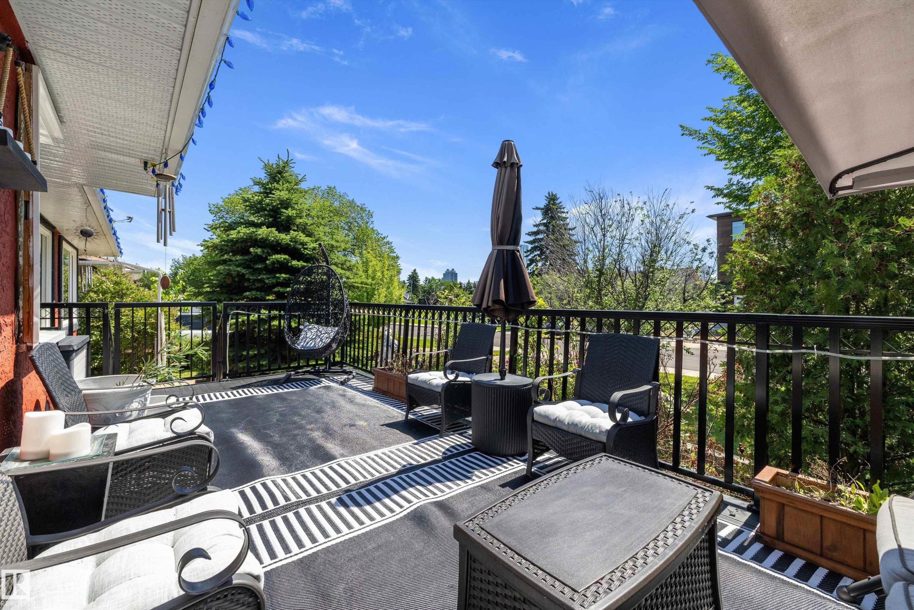 Spacious upper-level deck featuring a black metal railing and overhead soffit - 11124 110A Avenue Nw, Edmonton, AB
