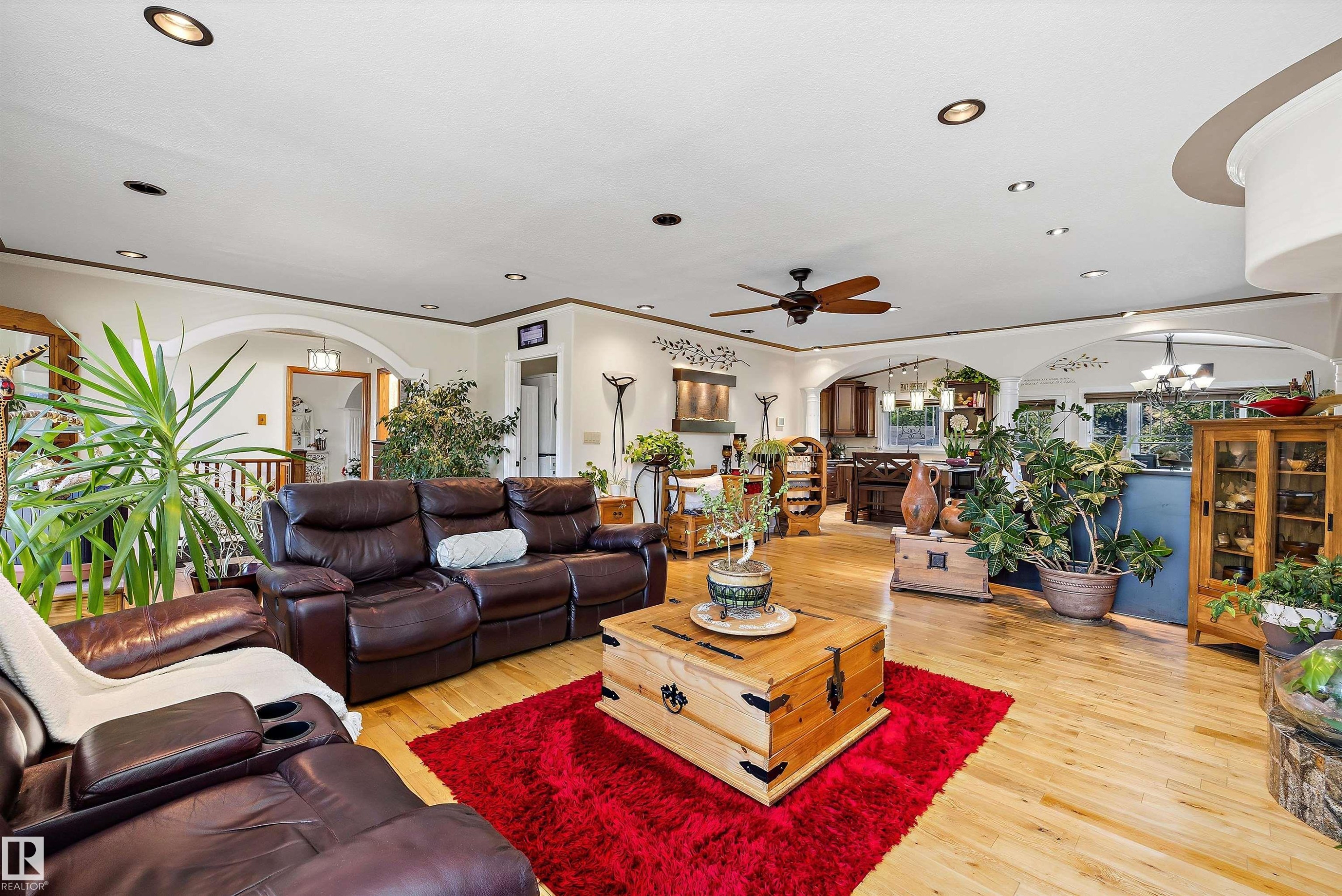 Spacious living area featuring light wood-finish flooring, recessed lighting, and a ceiling fan - 11124 110A Avenue Nw, Edmonton, AB