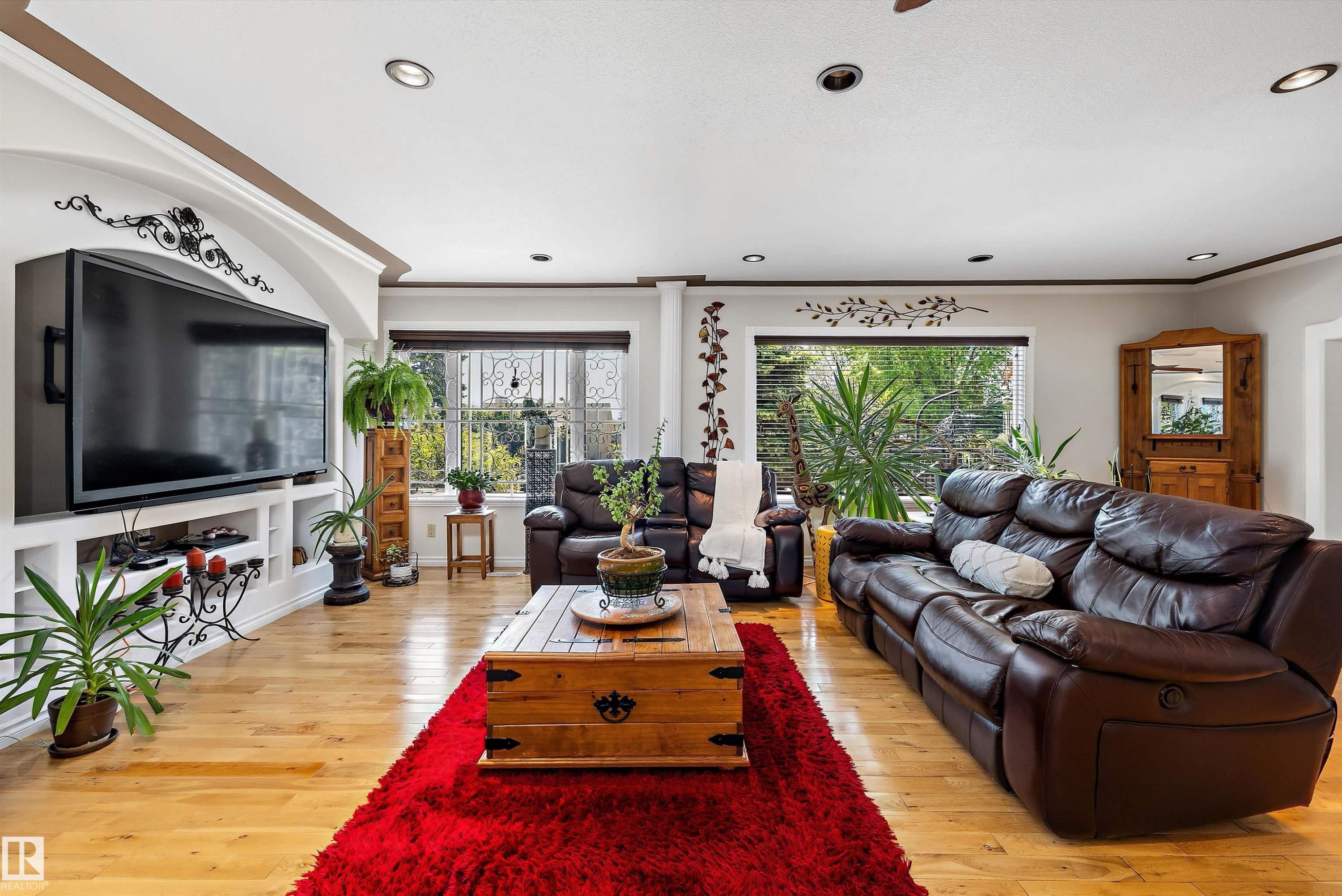 Living room featuring wood-finish flooring, recessed lighting, and a built-in media console with shelving - 11124 110A Avenue Nw, Edmonton, AB