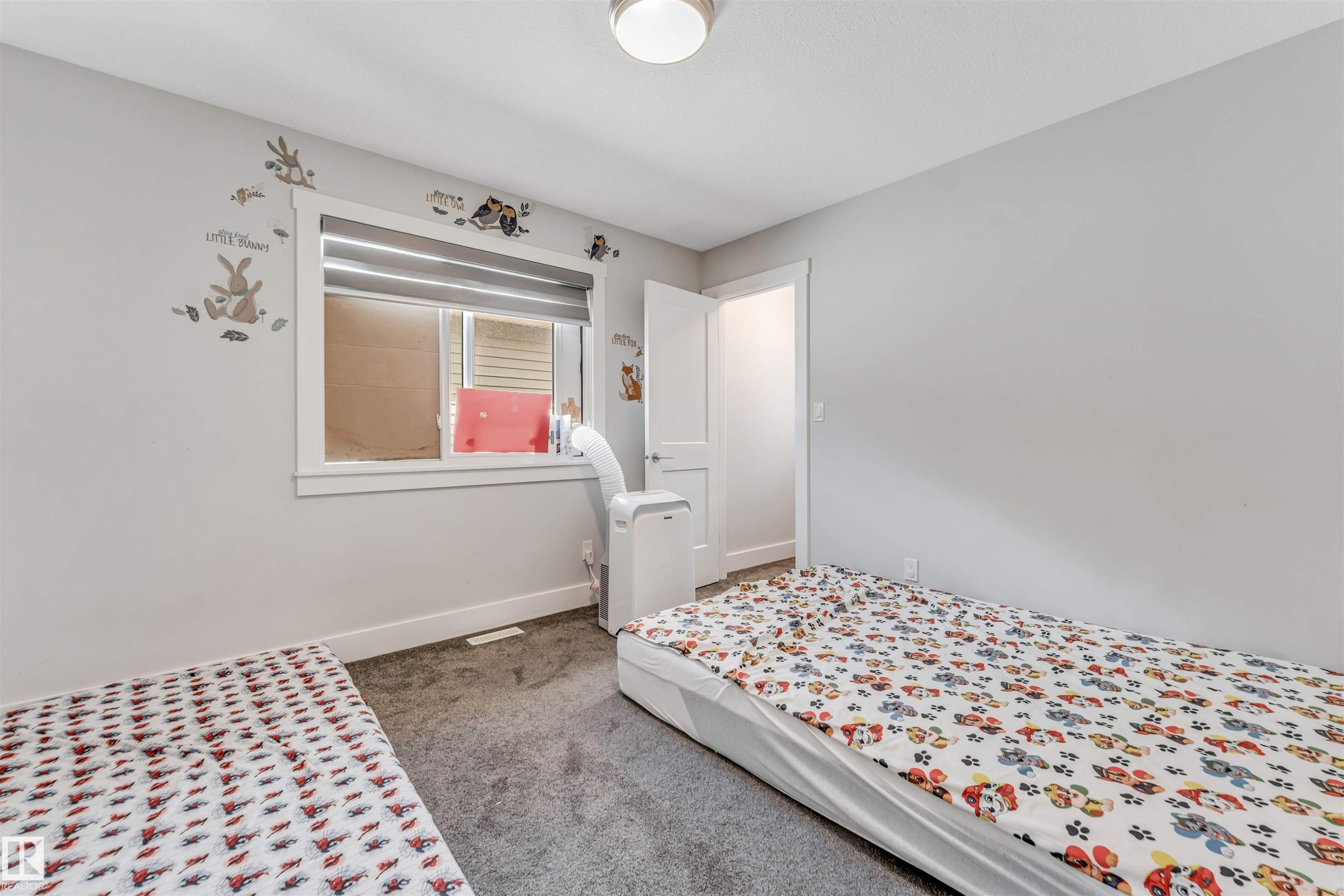 Carpeted room with a window featuring horizontal blinds - 8516 216 Street, Edmonton, AB