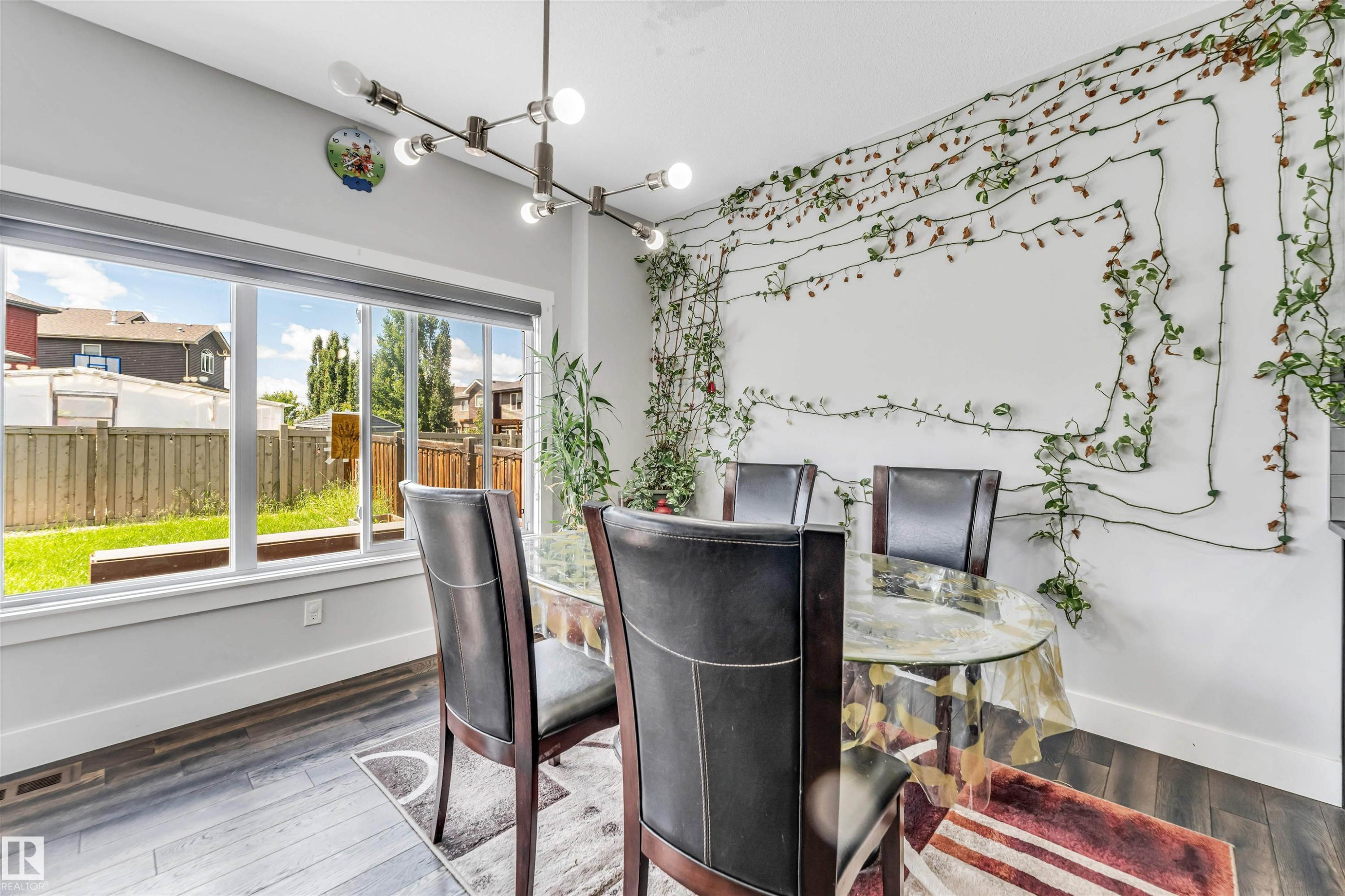 Dining area featuring wood-finish flooring and a large picture window - 8516 216 Street, Edmonton, AB